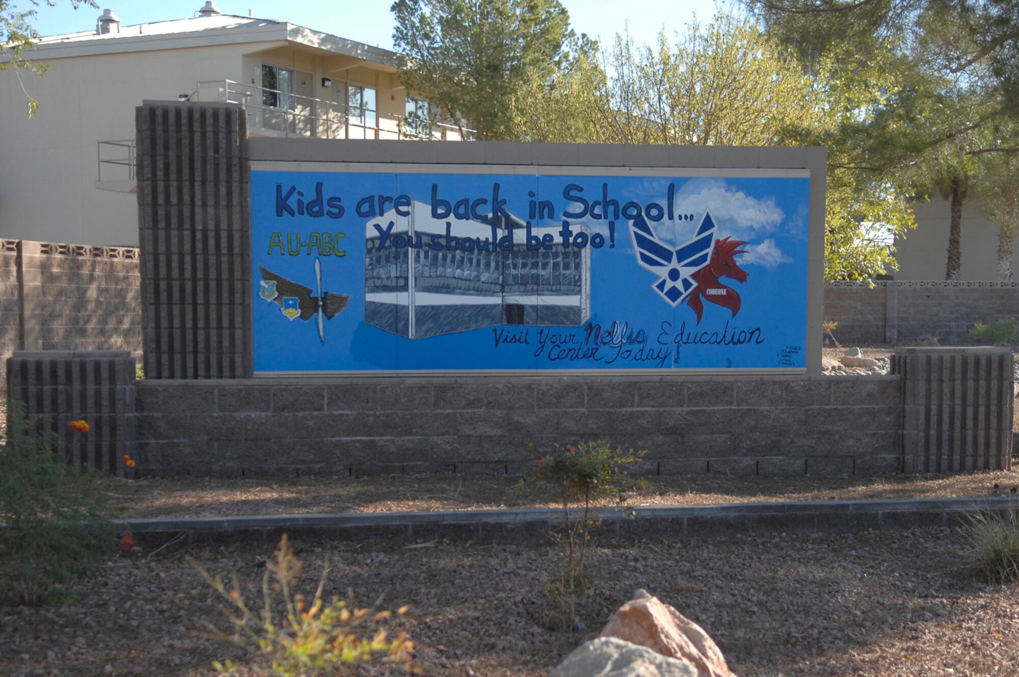 The painting by Senior Airman Melissa Cordero, 820th Red Horse Squadron, greets thousands of Airmen and visitors daily. Approximately every two and a half months, the 99th Air Base Wing Command Chief sends requests to encourage Airmen to show case their talents by designing and painting this sign. 
(U.S. Air Force Photo / Airman 1st Class Stephanie Rubi)