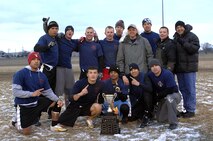 GRAND FORKS AIR FORCE BASE, N.D. – 5th Civil Engineer Squadron firefighters pose with the Dakota Cup after winning the first-ever Dakota Bowl Championship flag football game here Nov. 15. The 5th CES Fire Dawgs won the game 27-21 in overtime. The idea of the Dakota Bowl/Cup came from the sports directors at both bases. They wanted to get the best teams in each intramural sport to have a one-game playoff to decide the best in North Dakota. (U.S. Air Force photo by Senior Airman Kelly Timney)