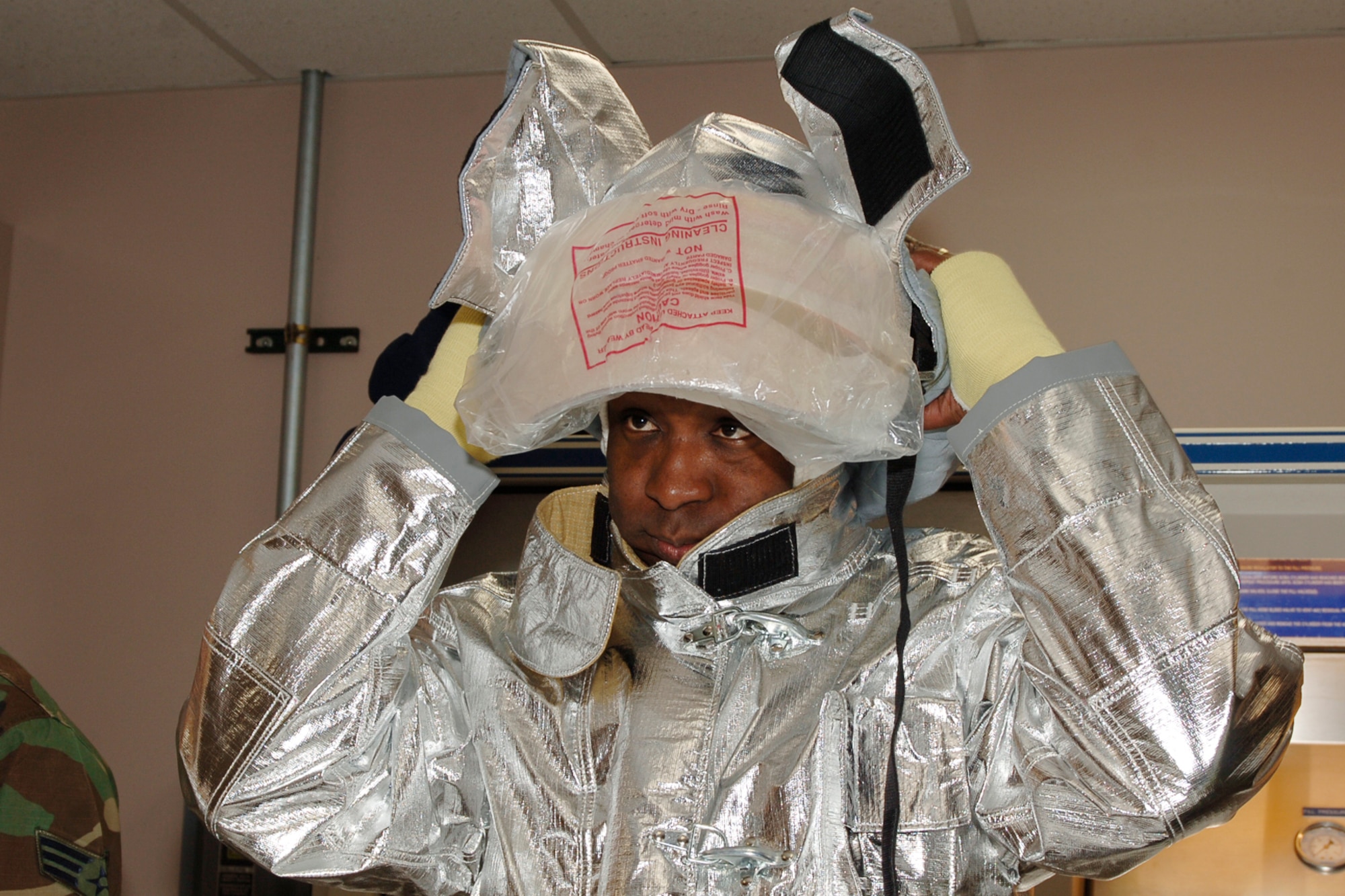 MCCONNELL AIR FORCE BASE, Kan. -- Maj. James Davis, 22nd Contracting Squadron commander, tries on a helmet and proximity bunker gear at the Fire Department, Nov. 14. Wing leadership learned about fire safety, personal protective equipment buddy checks and the objectives of the fire emergency training.  (Photo by Airman 1st Class Maria Ruiz)