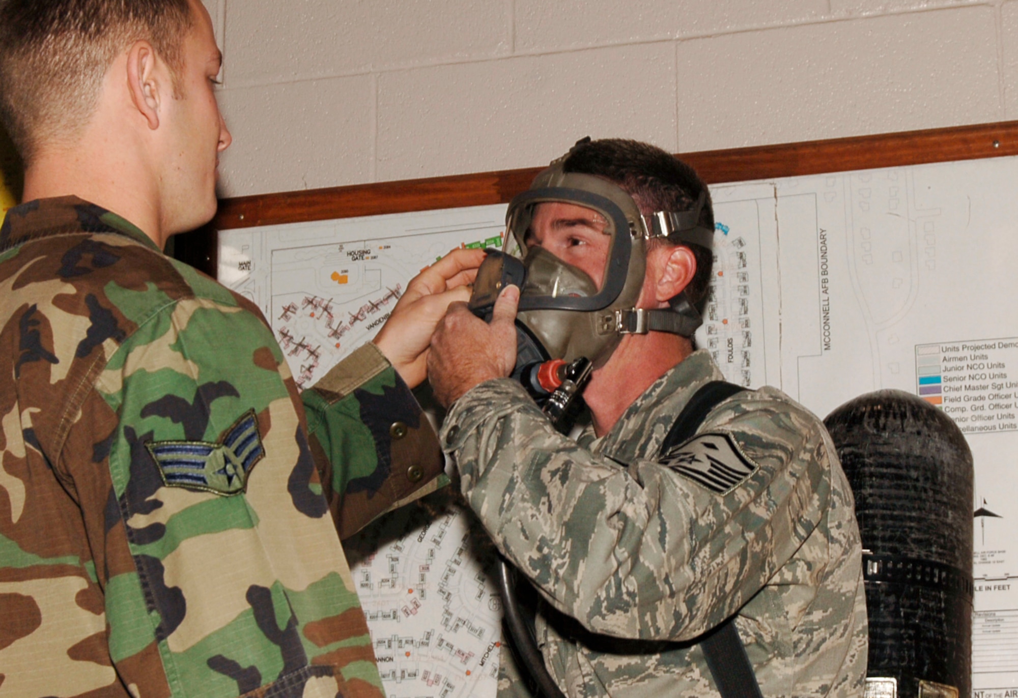 MCCONNELL AIR FORCE BASE, Kan. -- Senior Airman Joshua Hartwell, 22nd Civil Engineer Squadron, helps Master Sgt. Shad Lochner, 22nd Civil Engineer Squadron first sergeant, with his interspiro air pack at the fire department, Nov. 14. Sergeant Lochner was able to try on the air pack and test out the spiro hatch and bypass system to prepare for the hands on experience of answering a fire emergency. (Photo by Airman 1st Class Maria Ruiz)