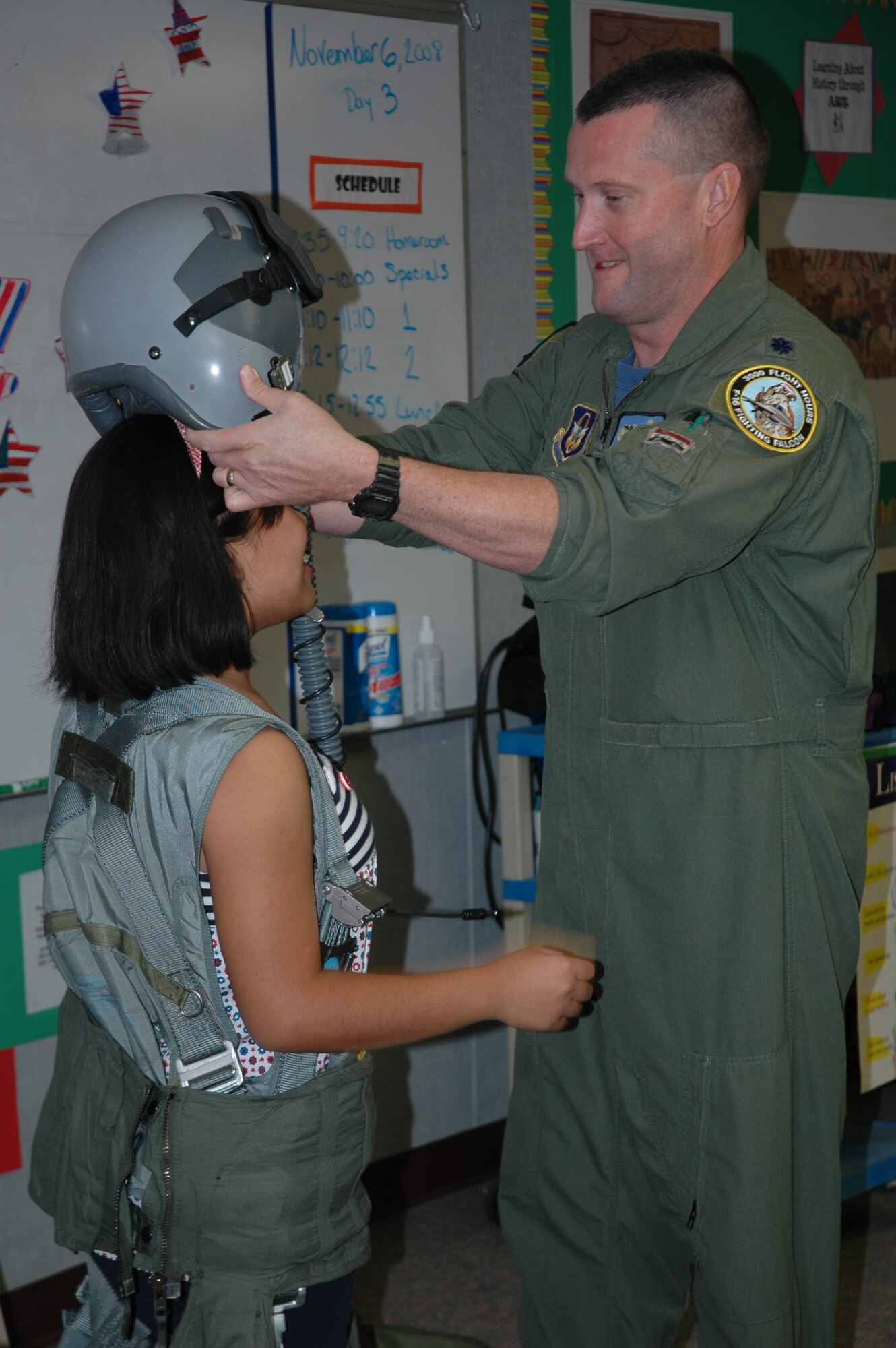 Lt. Col. Robert Buchanan, 944th Operations Flight commander, lets a student try on a helmet and harness during the annual Veteran's Day celebration Nov. 7 at Garden Lakes Elementary School in Avondale, Ariz. Eleven years ago, a teacher at the school started the celebration, held the Friday before Veteran's Day, as an effort to educate students on why they didn't have school Nov. 11. Veterans from nearly every war, race, age and sex have spoken to students throughout the years. (U.S. Air Force photo/Tech. Sgt. Susan Stout)