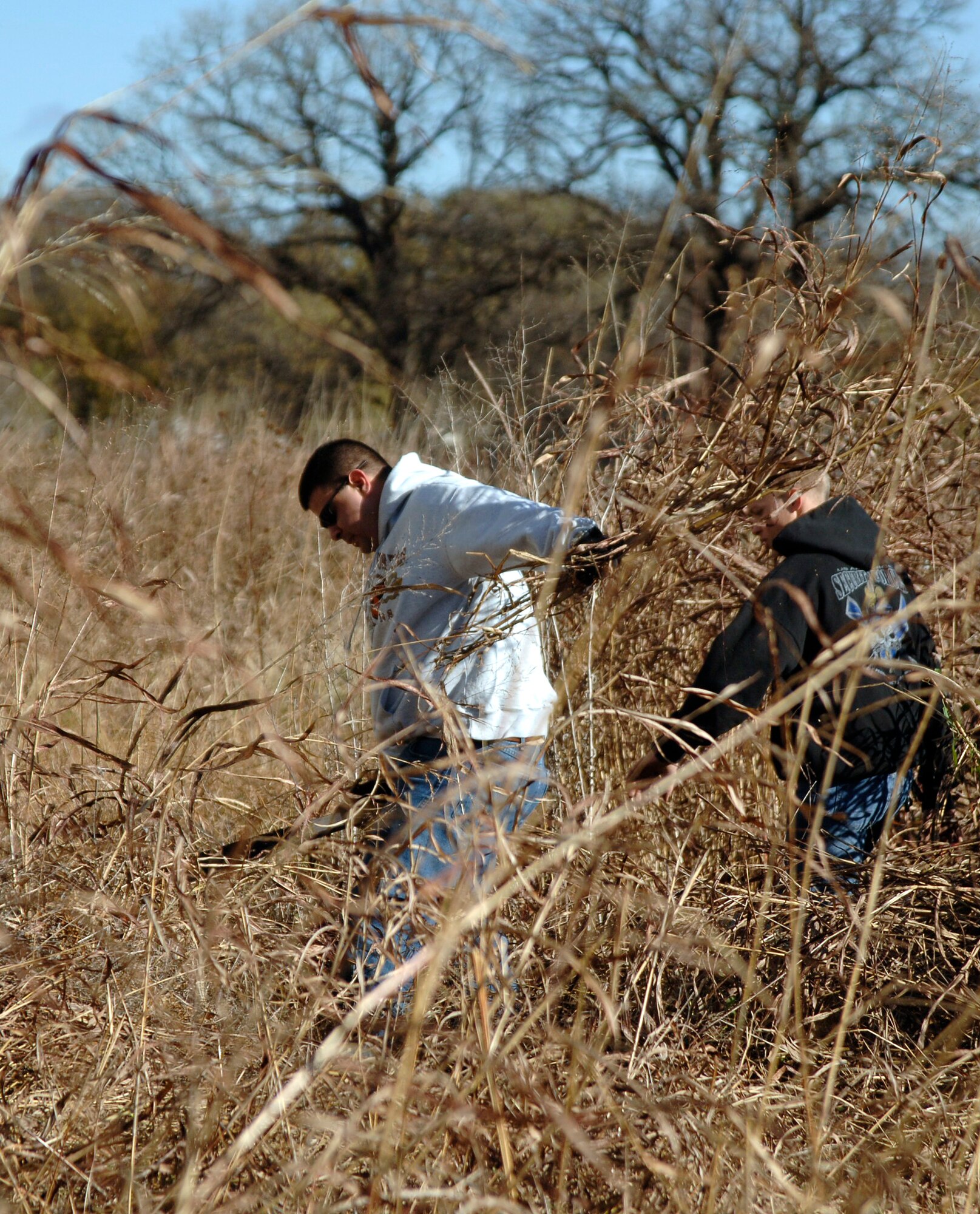 MCCONNELL AIR FORCE BASE, Kan. -- Senior Airman Michael Spinks, 433rd Maintenance Operation Squadron, Lackland Air Force Base, Texas, and Senior Airman William Frazier, 22nd Security Forces Squadron, use machetes to chop down weeds during a cleanup project at Joyland Amusement Park in Wichita, Nov. 15.  McConnell’s Route 56 spearheaded the project to revitalize the park and clean some of its recently vandalized areas.   (Photo by Staff Sgt. Ronald Lafosse)