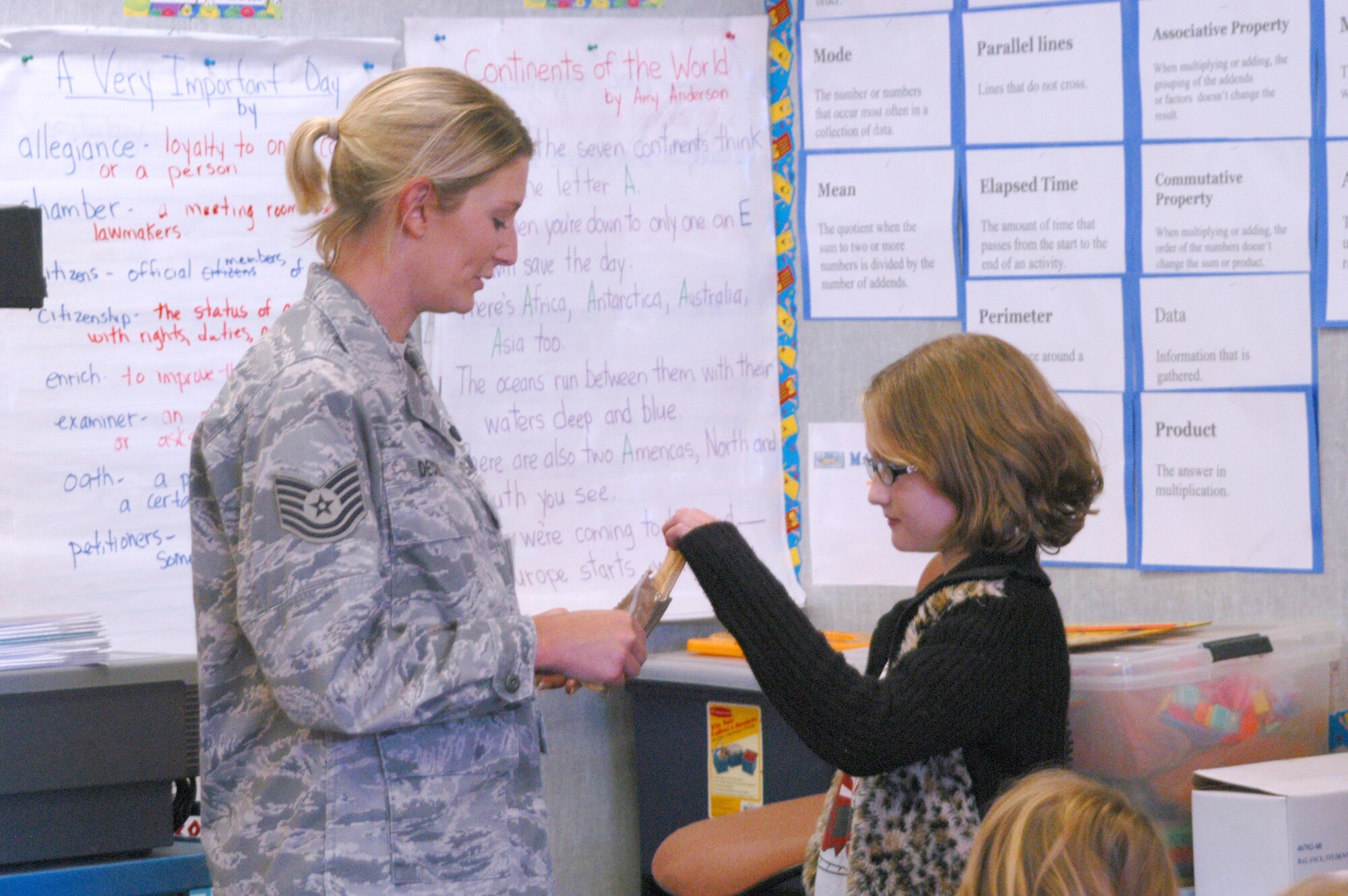 Tech. Sgt. Melissa Decker, 944th Services Flight, lets a student try a Meal Ready to Eat during the annual Veteran's Day celebration Nov. 7 at Garden Lakes Elementary School in Avondale, Ariz. Eleven years ago, a teacher at the school started the celebration, held the Friday before Veteran's Day, as an effort to educate students on why they didn't have school Nov. 11. Veterans from nearly every war, race, age and sex have spoken to students throughout the years. (U.S. Air Force photo/Staff Sgt. Denise Willhite)