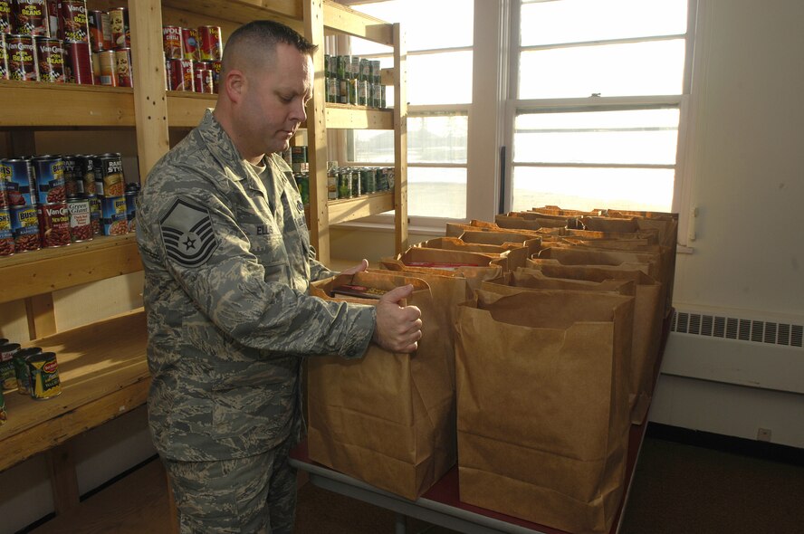 MINOT AIR FORCE BASE, N.D. -- Master Sgt. Brian Ellis, 5th Communications Squadron first sergeant, places a Thanksgiving food basket onto a table at the First Sergeant's Food Pantry here during Operation Warmheart Nov. 17. The food baskets will contain a complete Thanksgiving dinner and will be given out to Minot AFB families. The First Sergeant's Council conducts Operation Warmheart on an annual basis and this year will supply dinner to more than 180 Minot AFB families. (U.S. Air Force Photo by Senior Airman Joe Rivera)