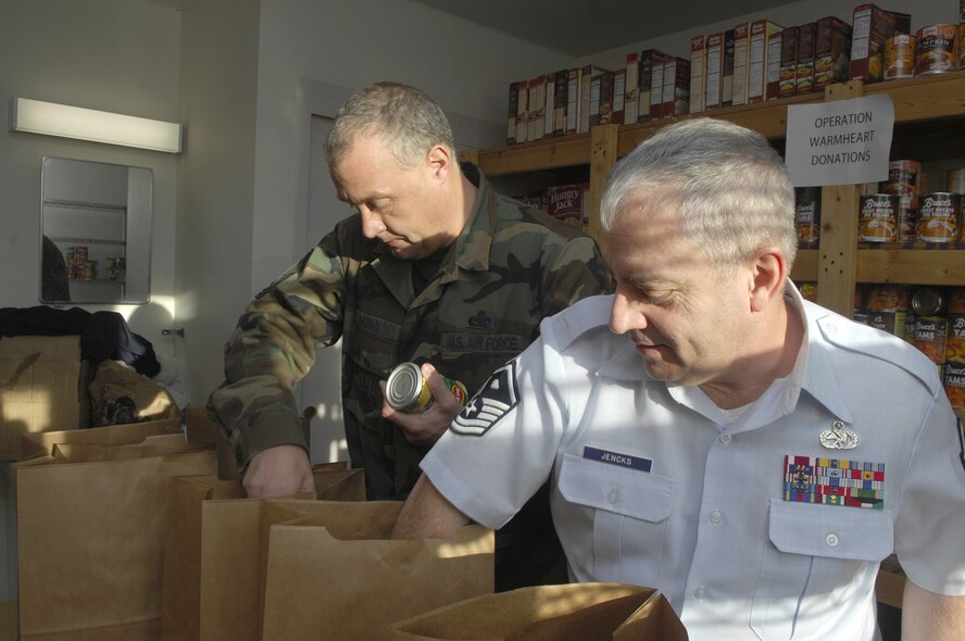 MINOT AIR FORCE BASE, N.D. -- Master Sgt. Todd Brown (left), 5th Maintenance Group first sergeant, and Master Sgt. Guy Jencks (right), 5th Maintenance Squadron first sergeant, put together a Thanksgiving food basket at the First Sergeant's Food Pantry here during Operation Warmheart Nov. 17. The food baskets will contain a complete Thanksgiving dinner and will be given out to Minot AFB families. The First Sergeant's Council conducts Operation Warmheart on an annual basis and this year will supply dinner to more than 180 Minot AFB families. (U.S. Air Force Photo by Senior Airman Joe Rivera)