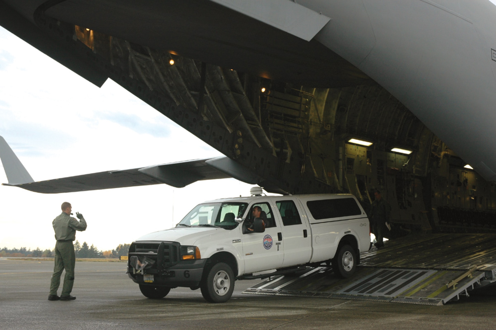 Staff Sgt. Shay Dennis, a loadmaster with the 728th Airlift Squadron, directs Roy Smith of FEMA Urban Search and Rescue Task Force One as he backs a truck onto a C-17 here Nov. 1.  The 446th Airlift Wing and Northwest FEMA members participated in a joint training exercise Oct. 31-Nov. 2 to be better prepared for disaster relief efforts.
