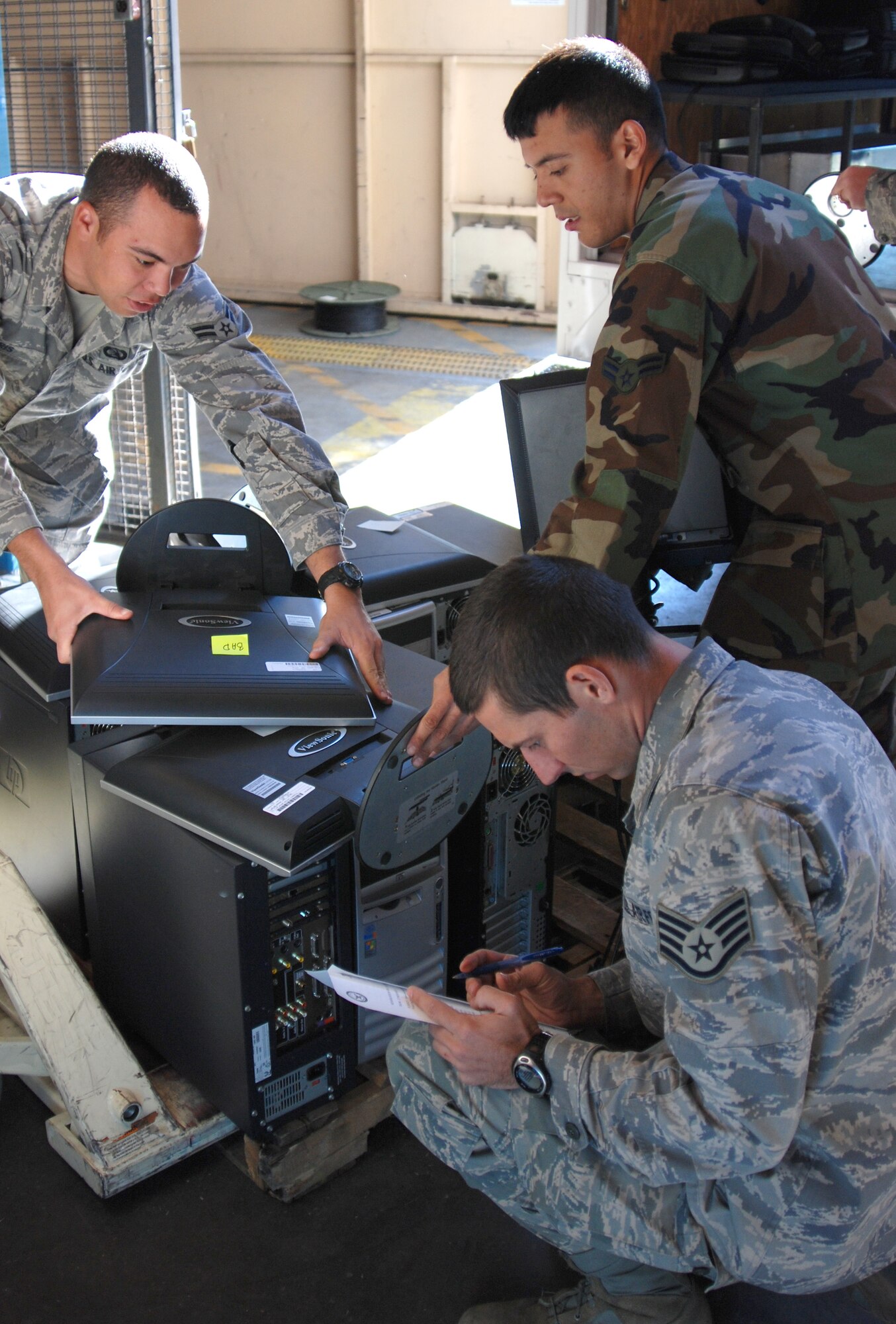 MCCONNELL AIR FORCE BASE, Kan. – Airmen form the 22nd Communications Squadron log turned in electronic equipment for temporary storage, Nov. 19, as a part of an effort to clean up automated data processing equipment lists in squadrons base wide. The unused government assets may be reissued to other Department of Defense organizations before being sold publicly.  (Photo by Airman 1st Class Jessica Lockoski)