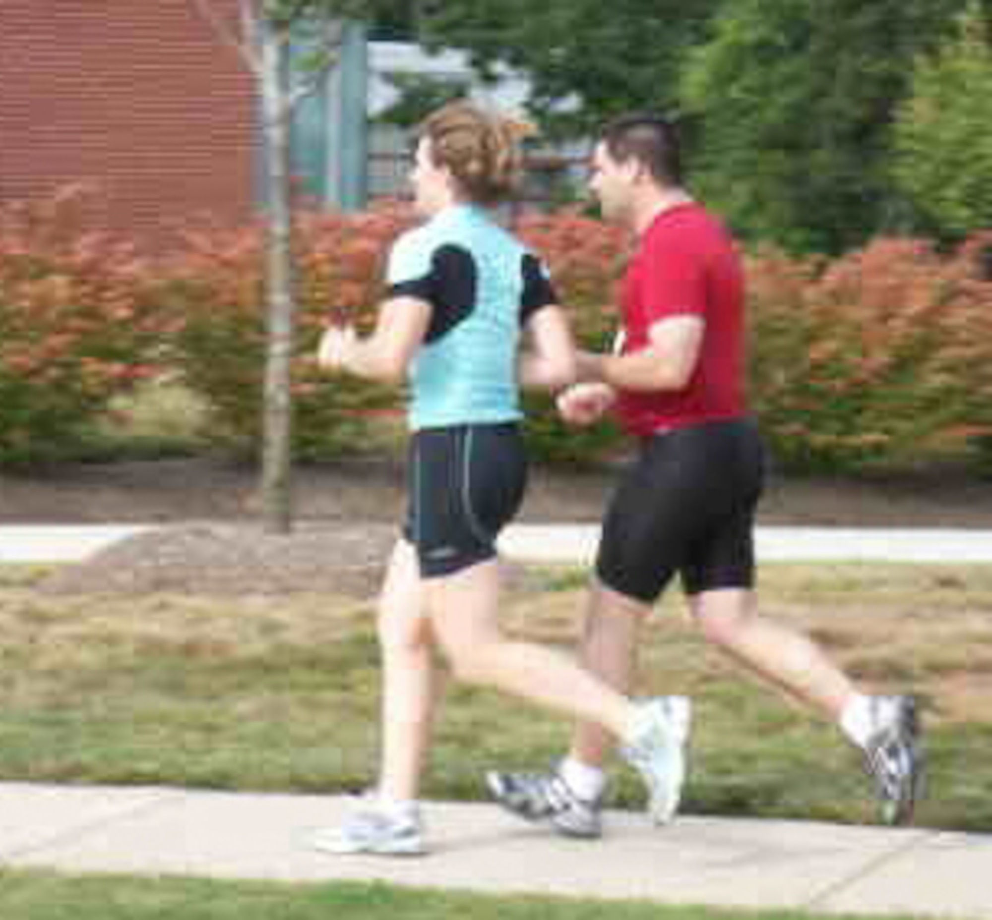 Maj. Kelli Molter, aide-de-camp to the commander of Air Force Reserve Command in the Pentagon, runs with her friend Chad Fenton. Mr. Fenton, who is blind, is personally trained and coached by Major Molter, who uses her Ironman experiences to assist physically disabled individuals compete in sporting events. (Courtesy photo)