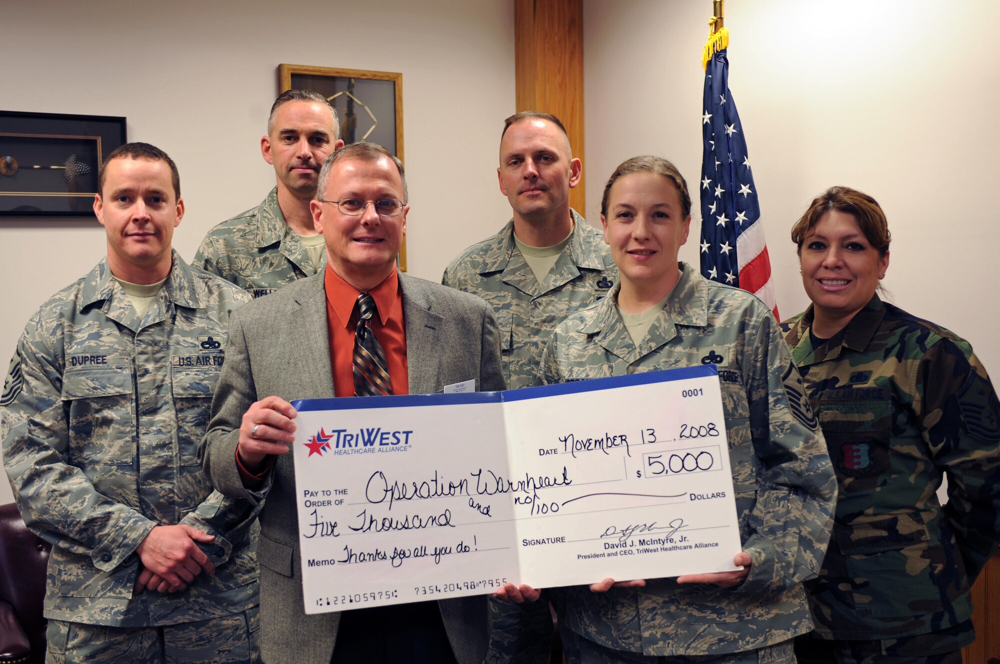 Ellsworth first sergeants are presented a check from Dr. Tim Ray, TriWest service area director of West Kansas and South Dakota, here, Nov. 13. The check was given as a donation to Operation Warmheart, a program that is designed to lend support to Airman and their families with financial aid. (U.S. Air Force photo by Airman Corey Hook)