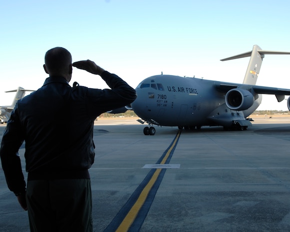 Col. John "Red" Millander salutes Brig. Gen. Bradley Pray as he taxis the new C-17 on Charleston AFB Nov. 18. The P-180 C-17 is the first new aircraft the base has received since 2003. Colonel Millander is the 437th Airlift Wing commander and General Pray is the deputy director of Air, Space and Information Operations, Headquarters Air Mobility Command, Scott AFB, Ill. (U.S. Air Force photo/Airman 1st Class Katie Gieratz) 

