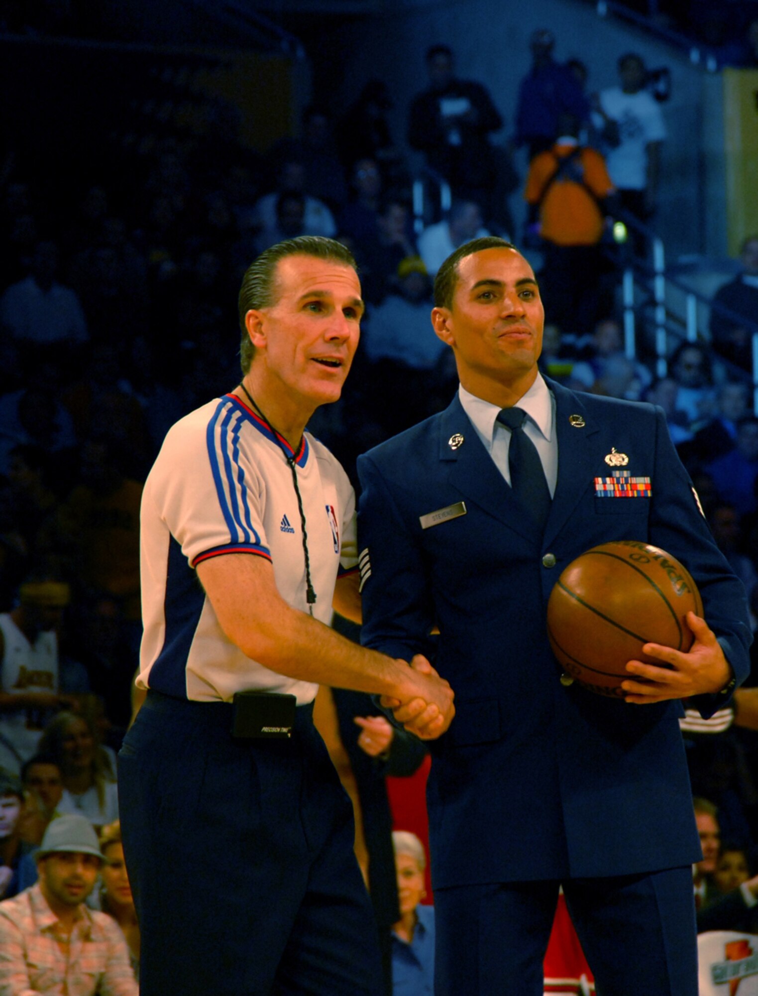 Staff Sgt. Andre Stevens presented the game ball prior to the start of the Lakers basketball game, Nov. 18.  In addition to presenting the ball, Lt. Col. Ivan Thompson sang the National Anthem and the Honor Guard Drill Team performed.  The event was one of many events held during Air Force Week, Nov. 14-21. (Photo by Joe Juarez)