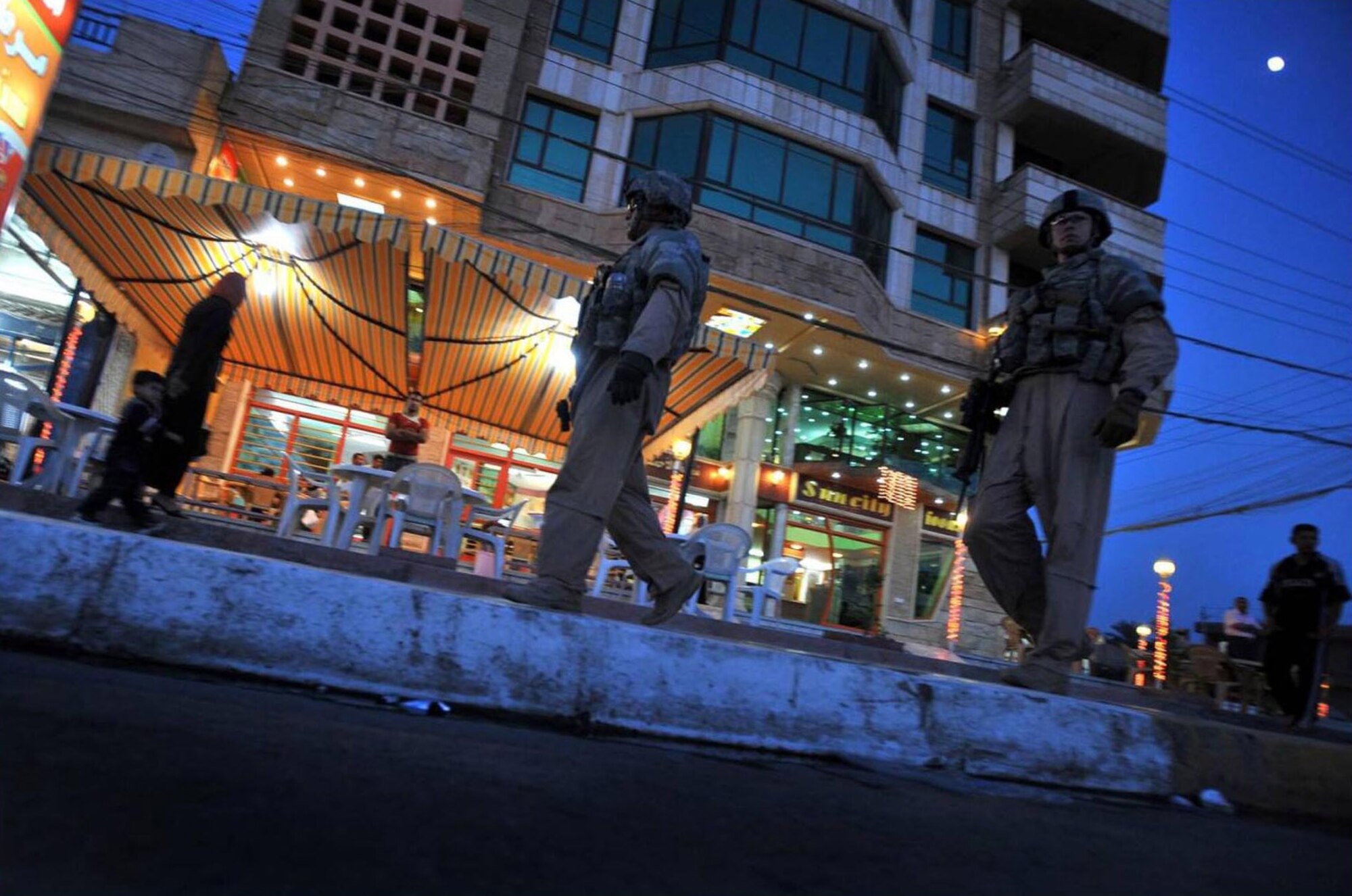 Airmen and Soldiers accompany Iraqi police officers on a walking patrol down Spruce Street to hand out flags, leaflets and hanging signs Nov. 8 in the Saydiyah community of southern Baghdad, Iraq. The Airmen are assigned to the 732nd Expeditionary Security Forces Squadron Det. 3 and attached to the Army's 716th Military Police Battalion, 18th MP Brigade. The Soldiers are assigned to the 1st Brigade Combat Team, 4th Infantry Division. (U.S. Navy photo/Petty Officer 2nd Class Todd Frantom) 
