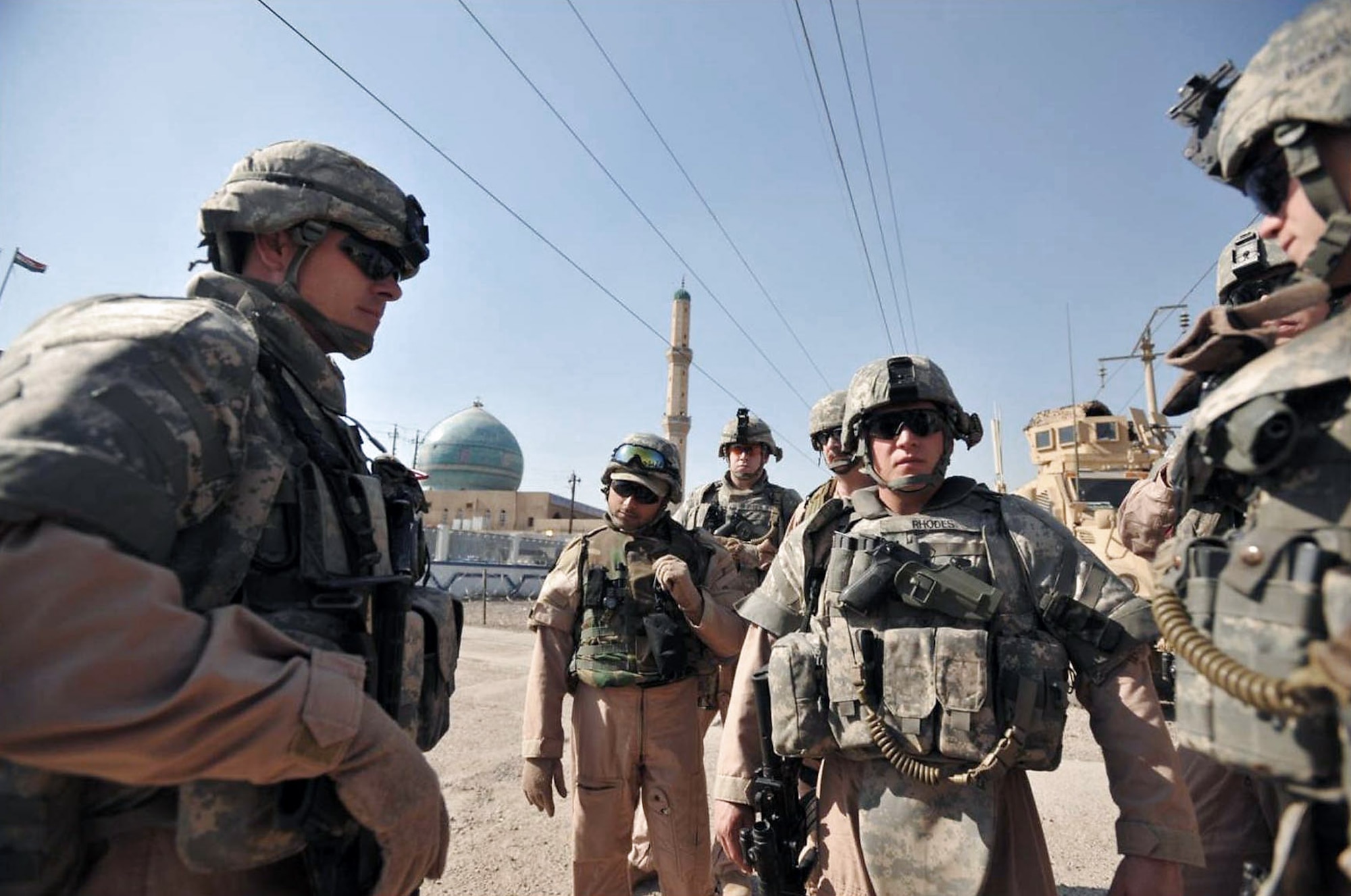 Airmen take a break while on a police transition team joint patrol with Iraqi police stop and update one another as they prepare to continue movement Nov. 7 in the Al-Bayaa community of southern Baghdad, Iraq. The Airmen are assigned to the 732nd Expeditionary Security Forces Squadron Det. 3 and attached to the Army's 716th Military Police Battalion, 18th MP Brigade. (U.S. Navy photo/Petty Officer 2nd Class Todd Frantom) 
