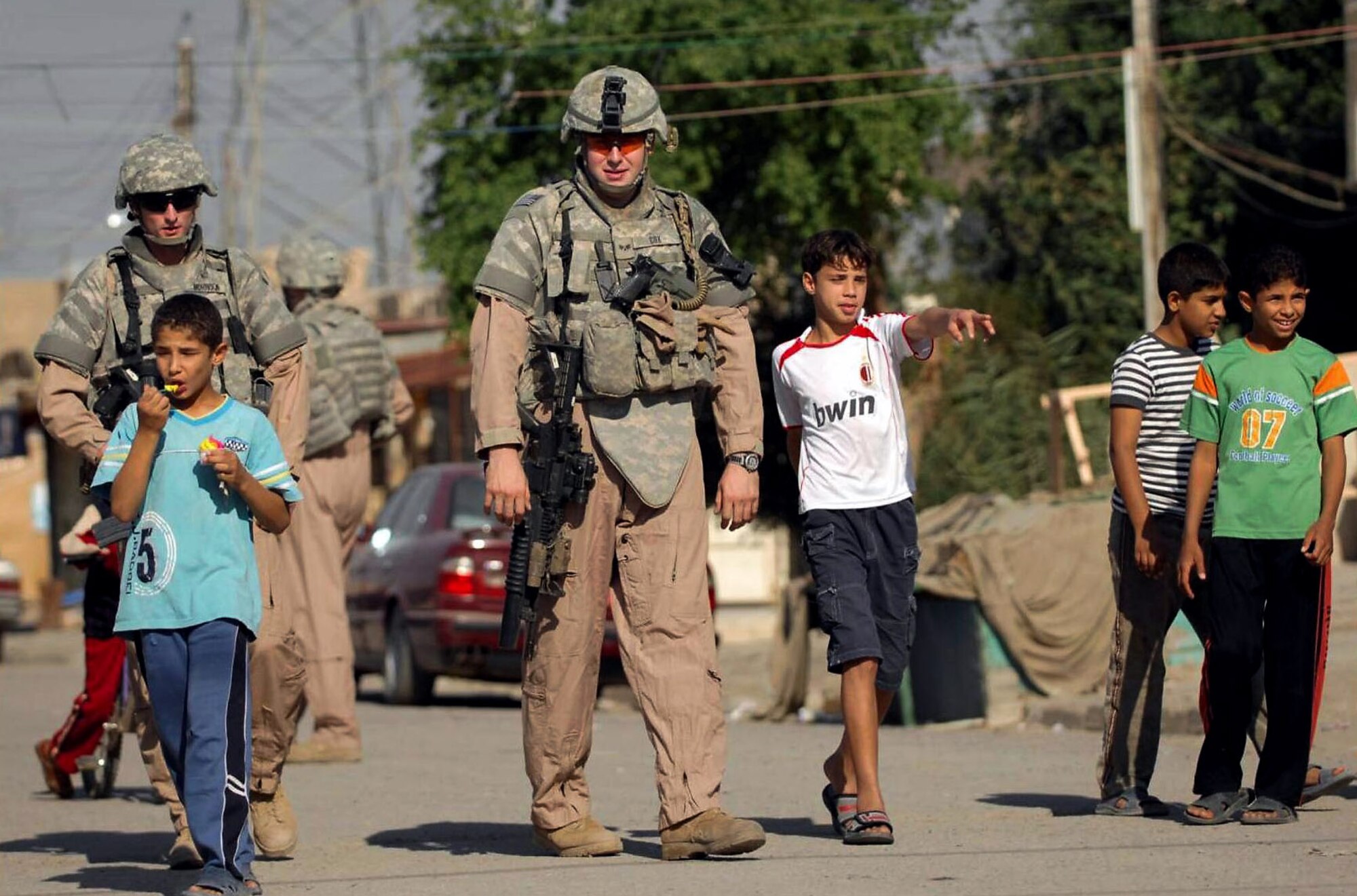 Children swarm around Airmen during a police transition team joint patrol with Iraqi police Nov. 7 in the Al-Bayaa community of southern Baghdad, Iraq. As security situations improve in the area, children and citizens are more comfortable to interact with both the IP and the coalition force police. The Airmen are assigned to the 732nd Expeditionary Security Forces Squadron Det. 3 and attached to the Army's 716th Military Police Battalion, 18th MP Brigade. (U.S. Navy photo/Petty Officer 2nd Class Todd Frantom) 
