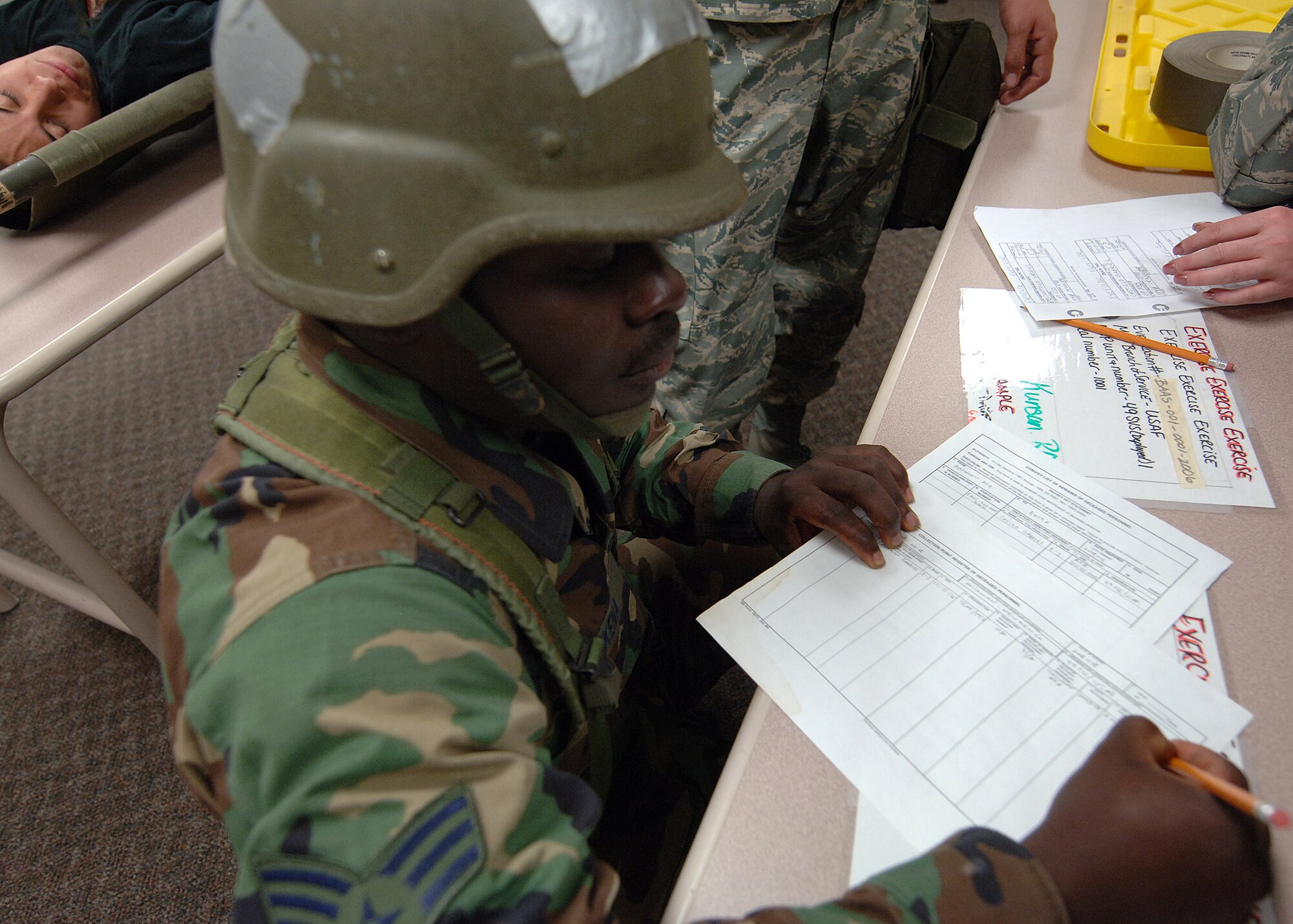 Senior Airman Joshua Kena, 49th Force Support Squadron, processes a casualty played by Airman 1st Class Gabriel Castillo, also 49 FSS, at Holloman Air Force Base, N.M., Nov.18. Casualties were being processed at the mortuary for the phase II exercise, Cornet Gold Rush 08-08. (U.S. Air Force photo/Airman 1st Class Michael Means)