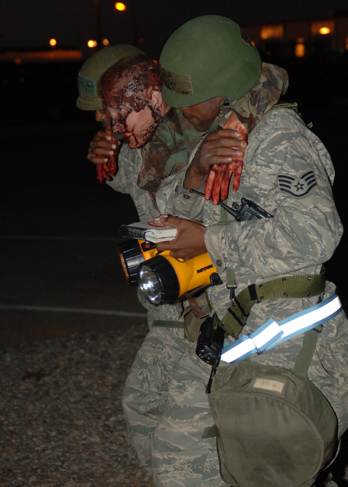 Senior Airman Joseph Petty and Staff Sgt Charles Jenkins, 49th Logistics Readiness Squadron, carry a victim played by Senior Airman Jacob Johnson, 49th Aircraft Maintenance Squadron, to safety at Holloman Air Force Base, N.M., Nov.17. Airman Petty and Sgt. Jenkins were doing post-attack reconnaissance for the phase II exercise, Cornet Gold Rush 08-08. (U.S. Air Force photo/Airman 1st Class Michael Means)