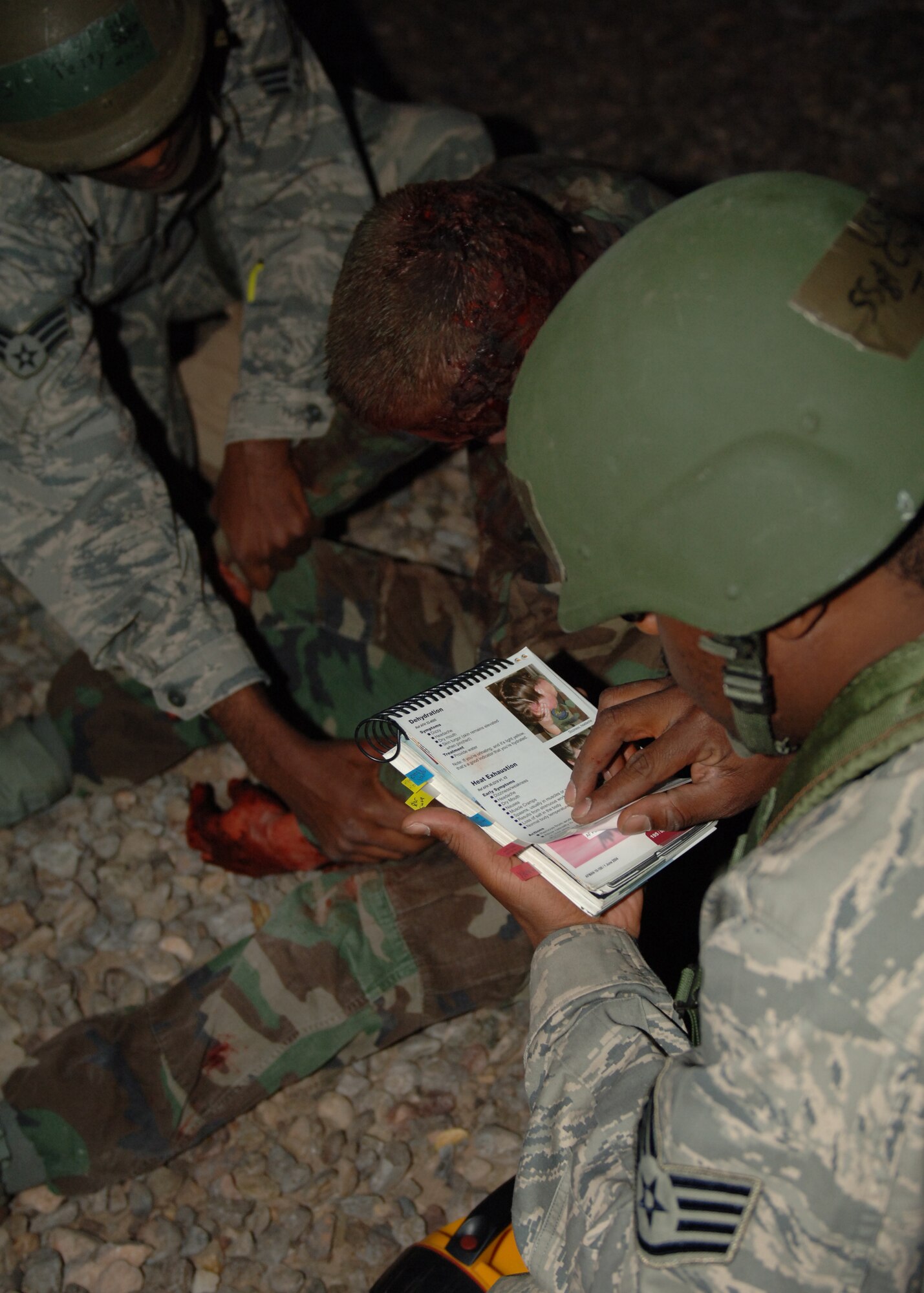 Staff Sgt Charles Jenkins, 49th Logistics Readiness Squadron, looks over his Airman's Manual as he administers self-aid and buddy care to a victim played by Senior Airman Jacob Johnson, 49th Aircraft Maintenance Squadron, at Holloman Air Force Base, N.M., Nov.17. Airman Petty and Sgt. Jenkins were doing post-attack reconnaissance for the phase II exercise, Cornet Gold Rush 08-08. (U.S. Air Force photo/Airman 1st Class Michael Means)
