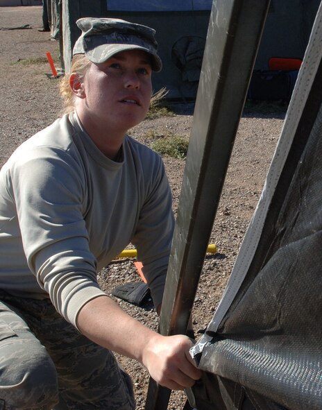 Airman 1st Class Krista Lawrence, 49th Civil Engineer Squadron, helps set up tents at the CE pit, a simulated deployed environment, for the phase II exercise, Cornet Gold Rush 08-08 at Holloman Air Force Base, N.M., Nov. 17. (U.S. Air Force photo/Airman 1st Class Michael Means)