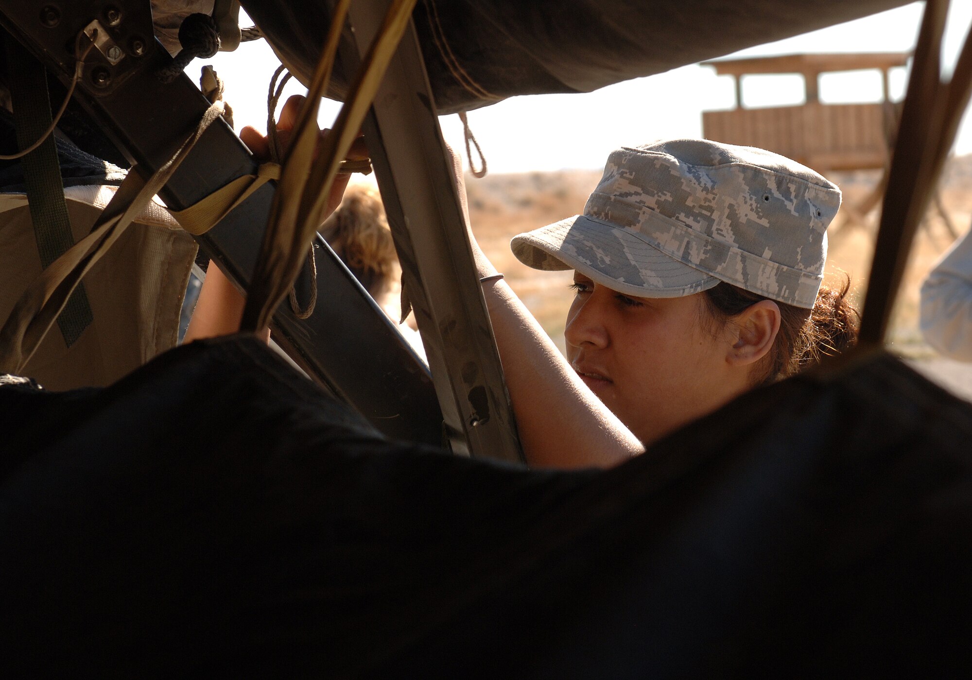 Airman 1st Class Karla Jimenez, 49th Civil Engineer Squadron, helps set up tents at the CE pit, a simulated deployed environment, for the phase II exercise, Cornet Gold Rush 08-08 at Holloman Air Force Base, N.M., Nov.17. (U.S. Air Force photo/Airman 1st Class Michael Means)