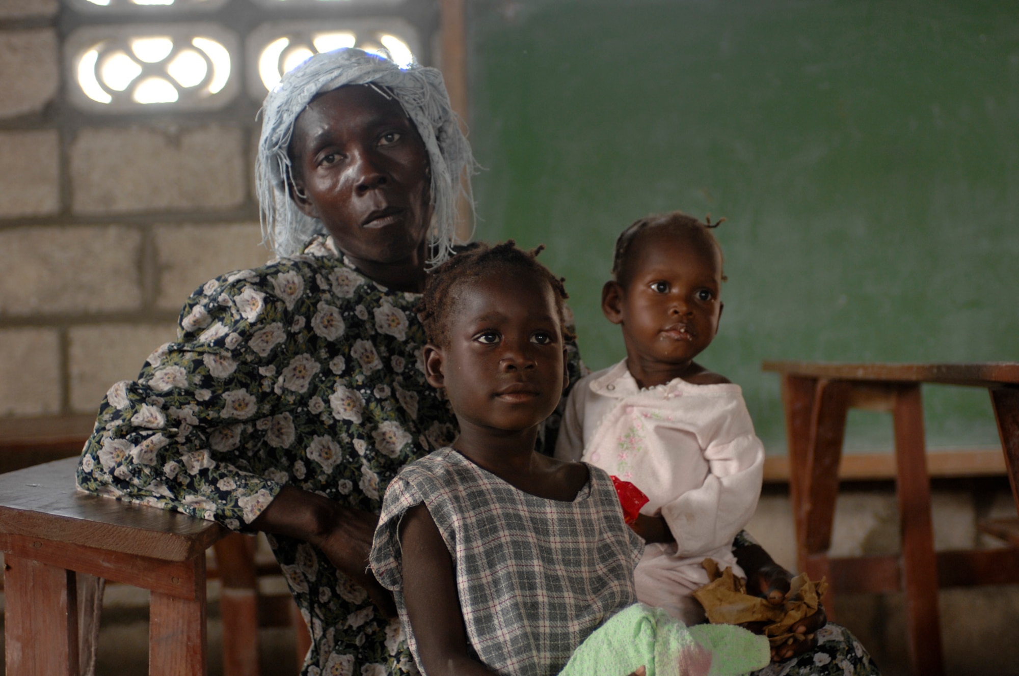 080924-N-9620B-014 - TERRE DE NEGRES, Haiti (Sept. 24, 2008) - A Haitian mother and her two daughters watch medical personnel from USS Kearsarge (LHD 3) conduct a health assessment in their village to determine future medical aid. Kearsarge embarked personnel from the Navy, Army, Air Force, Marines, and Coast Guard, along with medical personnel from the U.S. Public Health Service, Canadian Army, Air Force and Navy, Brazil, Project HOPE and International Aid are working together to conduct hurricane relief operations in Haiti.   (U.S. Navy photo by Mass Communication Specialist  2nd Class Erik C. Barker/Released)
