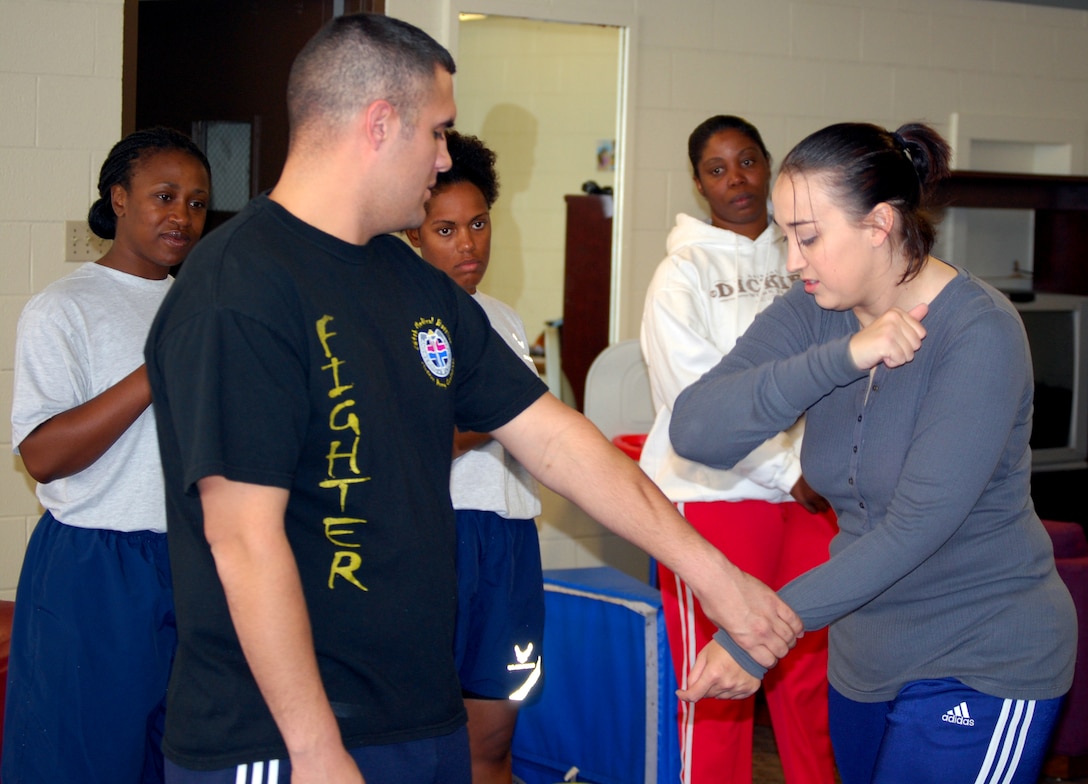 Staff Sgt. Leigh Wamsley, right, a Target Hardening instructor, demonstrates how to break a hand hold by an "attacker," played by Senior Airman Billy Chisum, during a self defense and awareness course Nov. 15. The course is designed to teach females how to become hard targets. (U.S. Air Force photo/Staff Sgt. Vernon Cunningham)