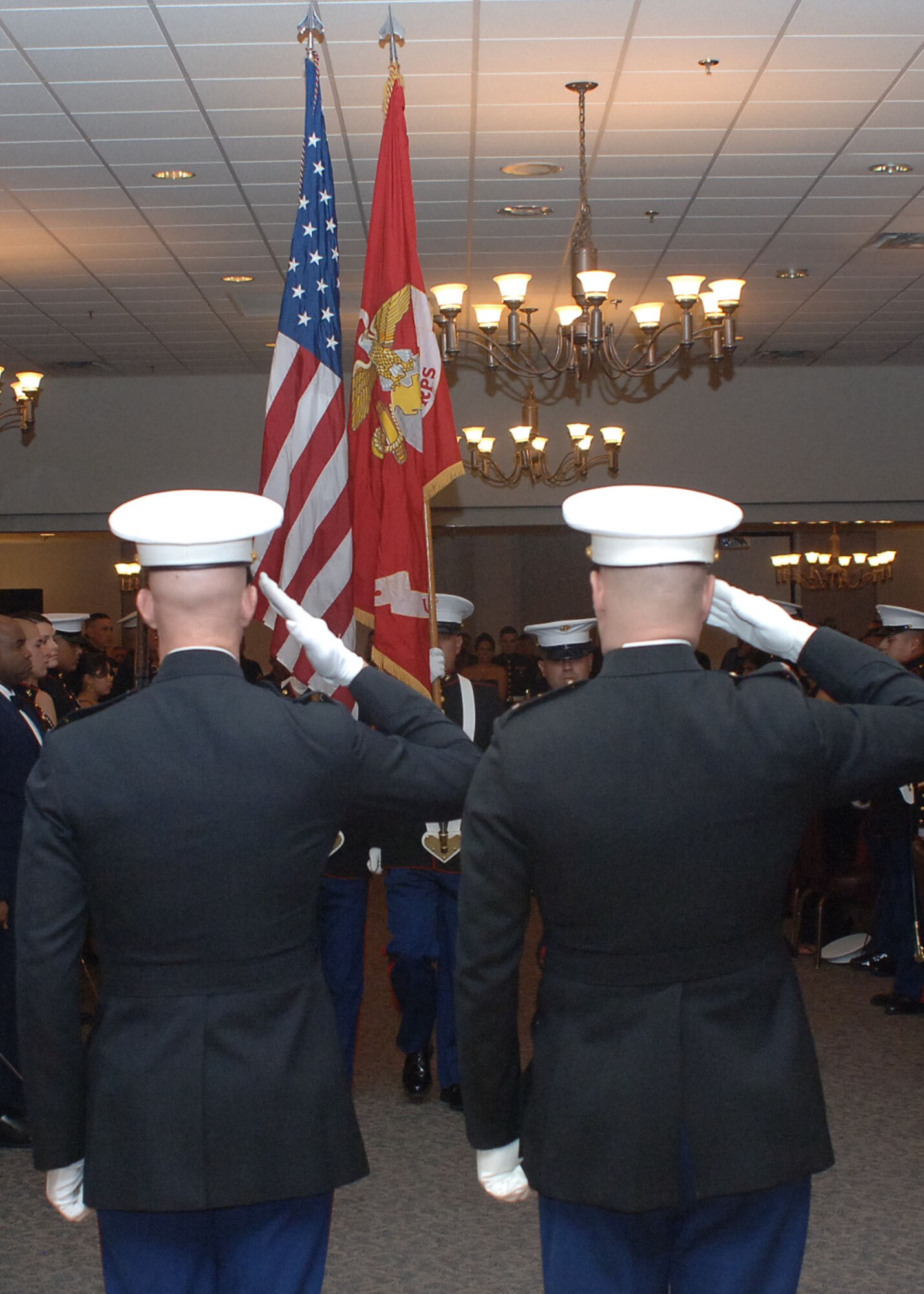 DYESS AIR FORCE BASE Texas-- Chief Warrant Officer 3 George Williams and Chief Warrant Officer 4 Bradley McCoy, from Detachment 1 Motor Transport Maintenance Company, 4th Maintenance Battalion, 4th Marine Logistics Group, salute while the colors are being presented during the Marine Corps Ball here, Nov. 8. The Marine Corps birthday is Nov. 10th and a ball is held annually to celebrate and boost morale.(U.S. Air Force photo/Senior Airman Felicia Juenke)