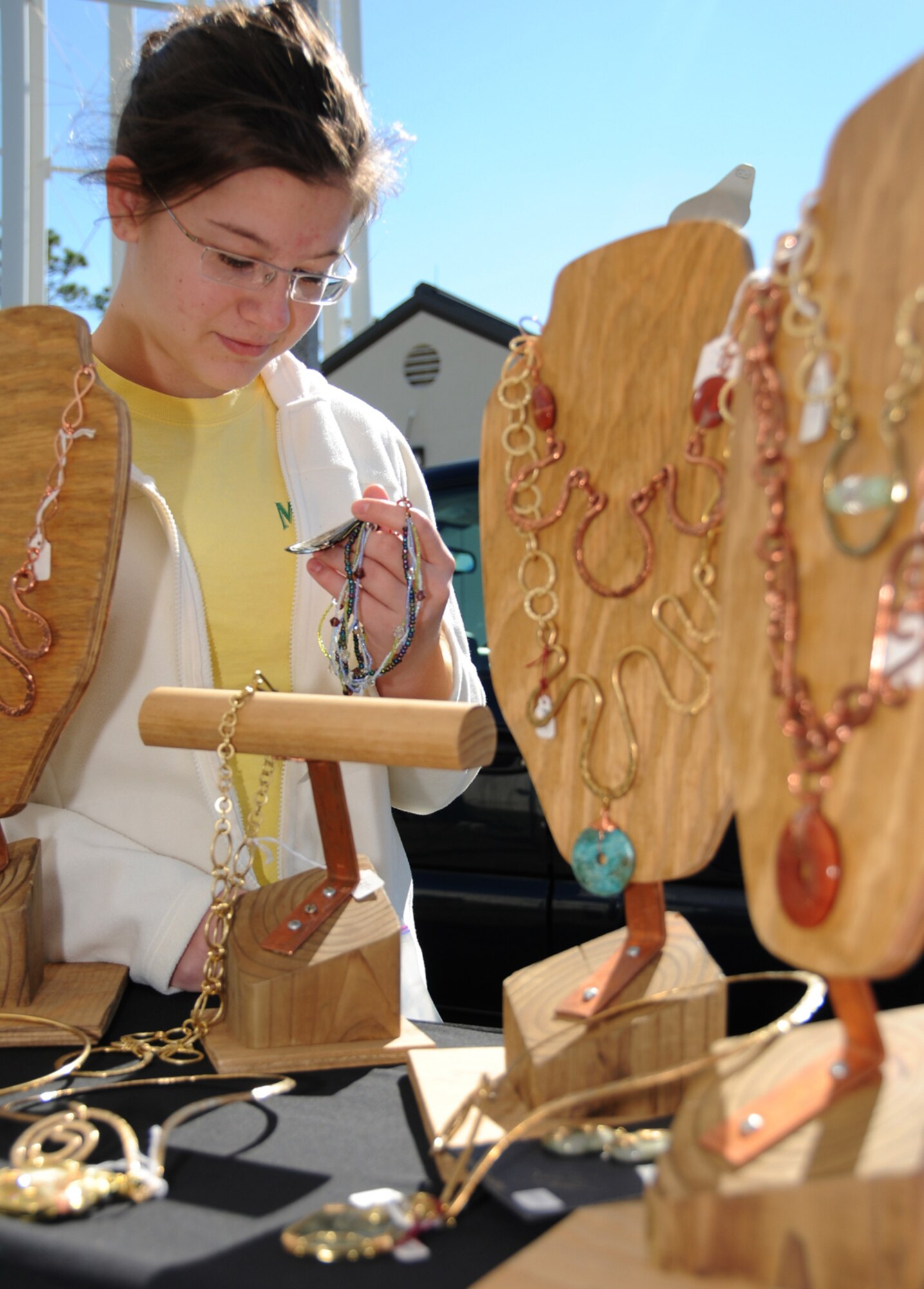 Dana Carlson, 15, daughter of retired Maj. Perry and Andrea Carlson of Biloxi, admires the jewelry at Saturday’s fall festival and holiday crafts fair.  (U.S. Air Force photo by Kemberly Groue)