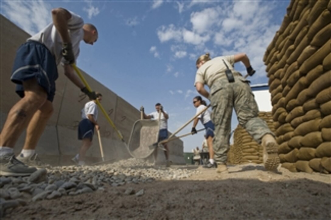 U.S. Air Force airmen from the 407th Expeditionary Security Forces Squadron spread gravel to create a walkway in their living area at Ali Air Base, Iraq, on Nov. 13, 2008.  Approximately 10,000 pounds of gravel are being spread in an effort to reduce the amount of mud being tracked through the living spaces.  
