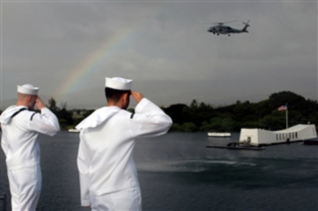 U.S. Navy sailors manning the rails aboard the Nimitz-class aircraft carrier USS Ronald Reagan render honors to the USS Arizona memorial, Pearl Harbor, Hawaii, Nov. 17, 2008. The USS Ronald Reagan is on a scheduled deployment operating in the U.S. 7th fleet area of responsibility.