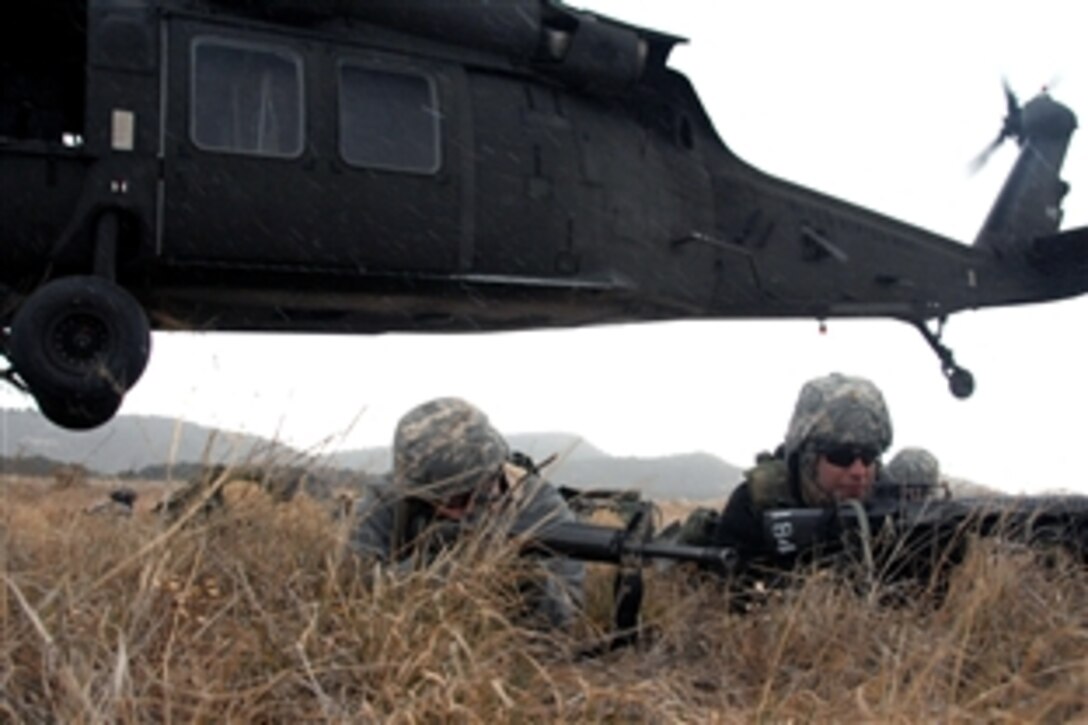 U.S. Army soldiers conduct air assault training as a UH-60 Black Hawk helicopter lifts off from behind them on Fort Carson, Colo., Nov. 14, 2008. The soldiers are assigned to the 157th Infantry Regiment's Company A, 1st Battalion and the Colorado Army National Guard. The Black Hawk crew are assigned to the 135th Aviation Regiment's 2nd Battalion.