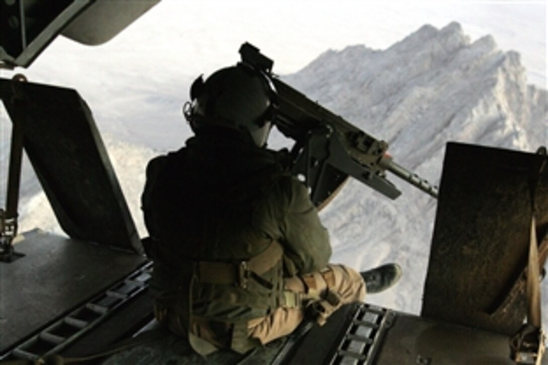 A U.S. Marine mans a machinegun while looking out the back door as  Marines assigned to Lima Company, 3rd Battalion, 8th Marines are transported in a CH-53 Super Stallion helicopter to replace the Marines of Fox Company, 2nd Battalion, 7th Marines, in Now Zad, in the Helmad Province of Afghanistan, Nov. 17, 2008.