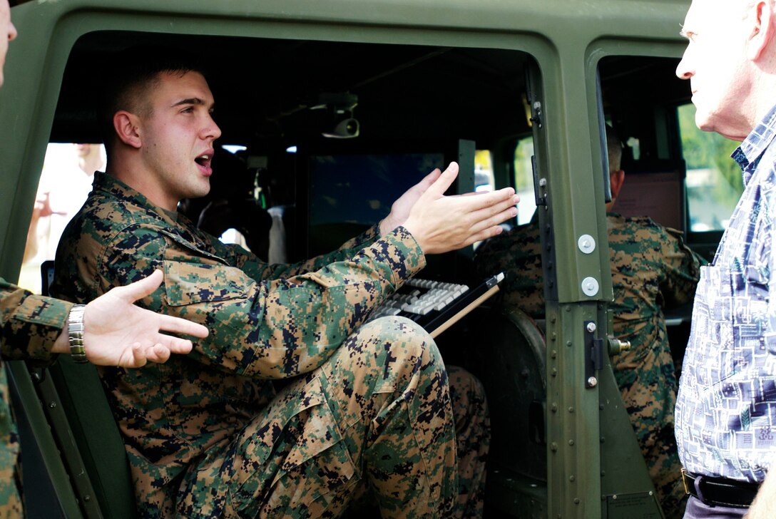 Sgt. Brad Burton, tactical data network administrator, III Marine Expeditionary Force G-6, explains how the Mobile Modular Command and Control Enhance prototype works. The MEP is the Marine Corps' answer to the need for establishing quick, on-the-move command and control.