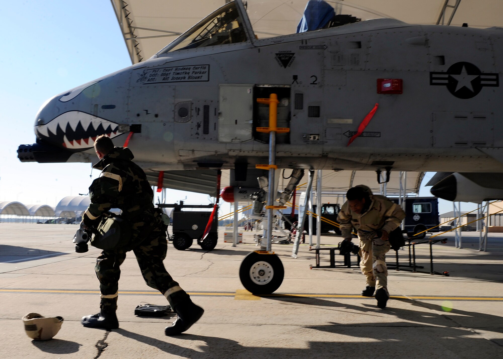 MOODY AIR FORCE BASE, Ga. -- Tech. Sgt. Thomas Gibson, A-10C Thunderbolt II crew chief and Airman 1st Class Todd Padgett propulsion apprentice, both members of the 75th Aircraft Maintenance Unit, run to a simulated bunker to take cover while alarm red sounds during a base wide exercise here Nov. 20. (U.S. Air Force photo by Senior Airman Brittany Barker)

