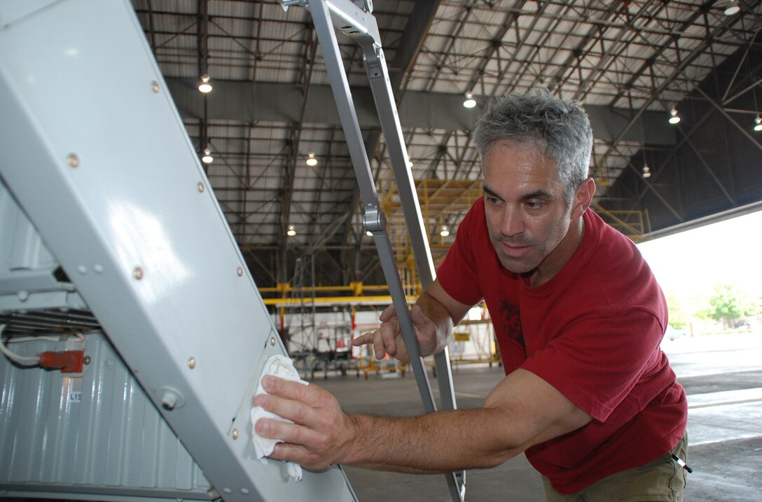 Tech. Sgt. Paul Carissimo takes time to proudly stop and polish one of the 932nd Airlift Wing’s C-9C aircraft stairs inside Hangar One.  U.S. Air Force photo/Maj. Stan Paregien