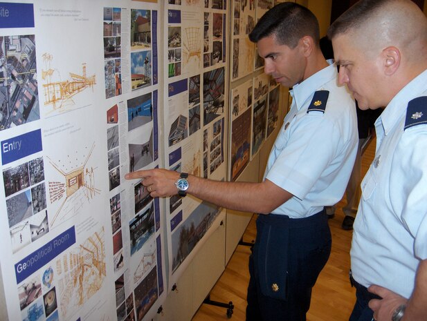 NELLIS AIR FORCE BASE, Nev. – Maj. Matteo Martemucci, 547th Intelligence Squadron director of operations, reviews design concepts for the 547th IS’s Threat Training Facility with Lt. Col. Greg Brown. The University of Nevada Las Vegas submitted the design plans during an opening ceremony for the school’s downtown design center. (U.S. Air Force photo by Maj. Matteo G. Martemucci)