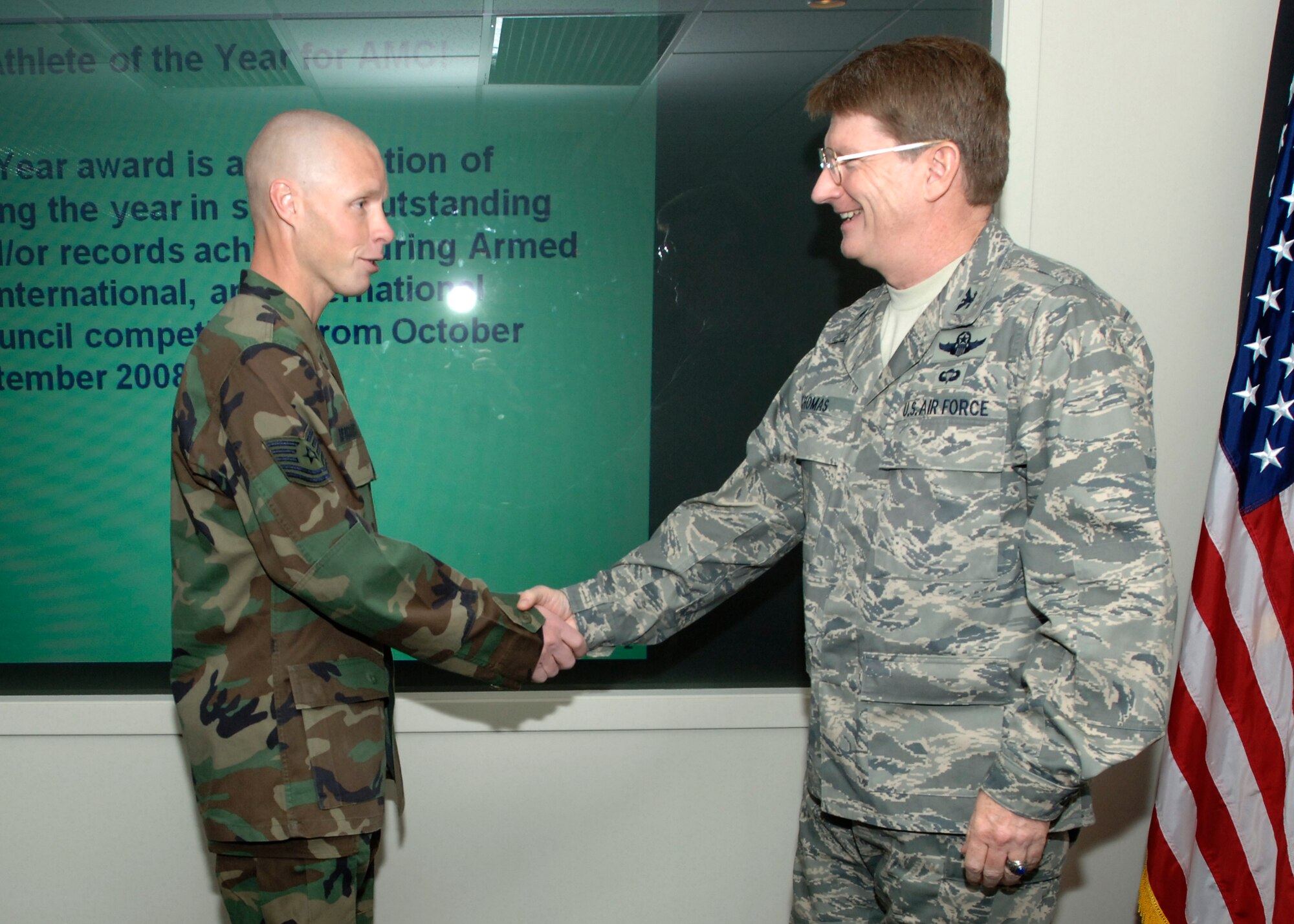 FARICHILD AIR FORCE BASE, Wash. – Col. Robert Thomas, 92nd Air Refueling Wing Commander, presents Tech. Sgt. Micheal Bergquist, 242nd Combat Communication Squadron satellite communications technician and currently an augmentee with the 92nd Security Forces Squadron, a coin for his outstanding achievement for receiving Athlete of the Year for the Air Force.  Sergeant. Bergquist has participated in 21 events including marathons, triathlons, decathlons, half marathons, sprint marathons, and five kilometer road races. He was the overall winner in 18 events and set new records in 10 of them. (U.S. Air Force photo / Airman 1st Class Melissa Barnett) 