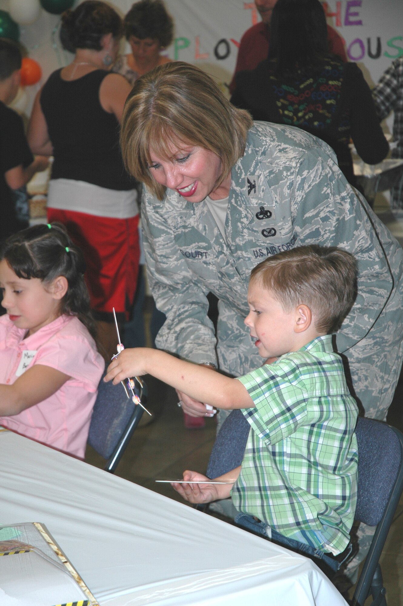 Col. Linda McCourt, 944th Mission Support Group commander talks with a son of a deployed member Nov. 13 during the 944th Fighter Wing-sponsored Deployed Spouses' Dinner at the Luke Community Chapel.  Each month, the Luke chaplain's offices conduct a dinner for families of deployed Airmen which offers free food, arts and crafts for the children, and door prizes in an effort to offer support to military families while their loved one is deployed.  (U.S. Air Force photo/Staff Sgt. Denise Willhite)