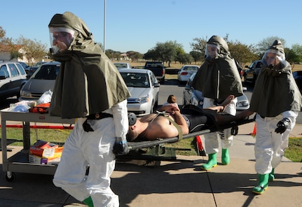 Capt. Matthew Dietrich (from left), Master Sgt. Noppamat Harmon and Senior Airman Antonieta Jara, 12th Medical Group, carry a simulated victim to the medical group during the exercise portion of the 2008 Operational Readiness Inspection at Randolph Air Force Base, Texas. (U.S. Air Force photo by Steve White)