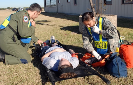 Maj. Melvin Marque (left) and Staff Sgt. Leslie Ponce, first responders from the 12th Medical Group, prepare simulated victim 2nd Lt. Sherry Craddock, 562nd Flying Training Squadron, for transport to a medical facility during the exercise portion of the 2008 Operational Readiness Inspection at Randolph Air Force Base, Texas. (U.S. Air Force photo by Steve White)