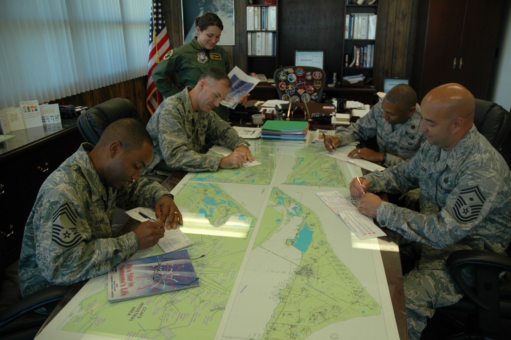 45th Operations Group Superintendent Chief Master Sgt. Frank Evans, Commander Col. Bernie Gruber, Vice Commander Lt. Col. Myron Fortson and First Sergeant Senior Master Sgt. Jeffrey Lizak fill out their Combined Federal Campaign forms with CFC keyworker Capt. Shannon McKimmie (standing). (U.S. Air Force photo by Airman 1st Class David Dobrydney)