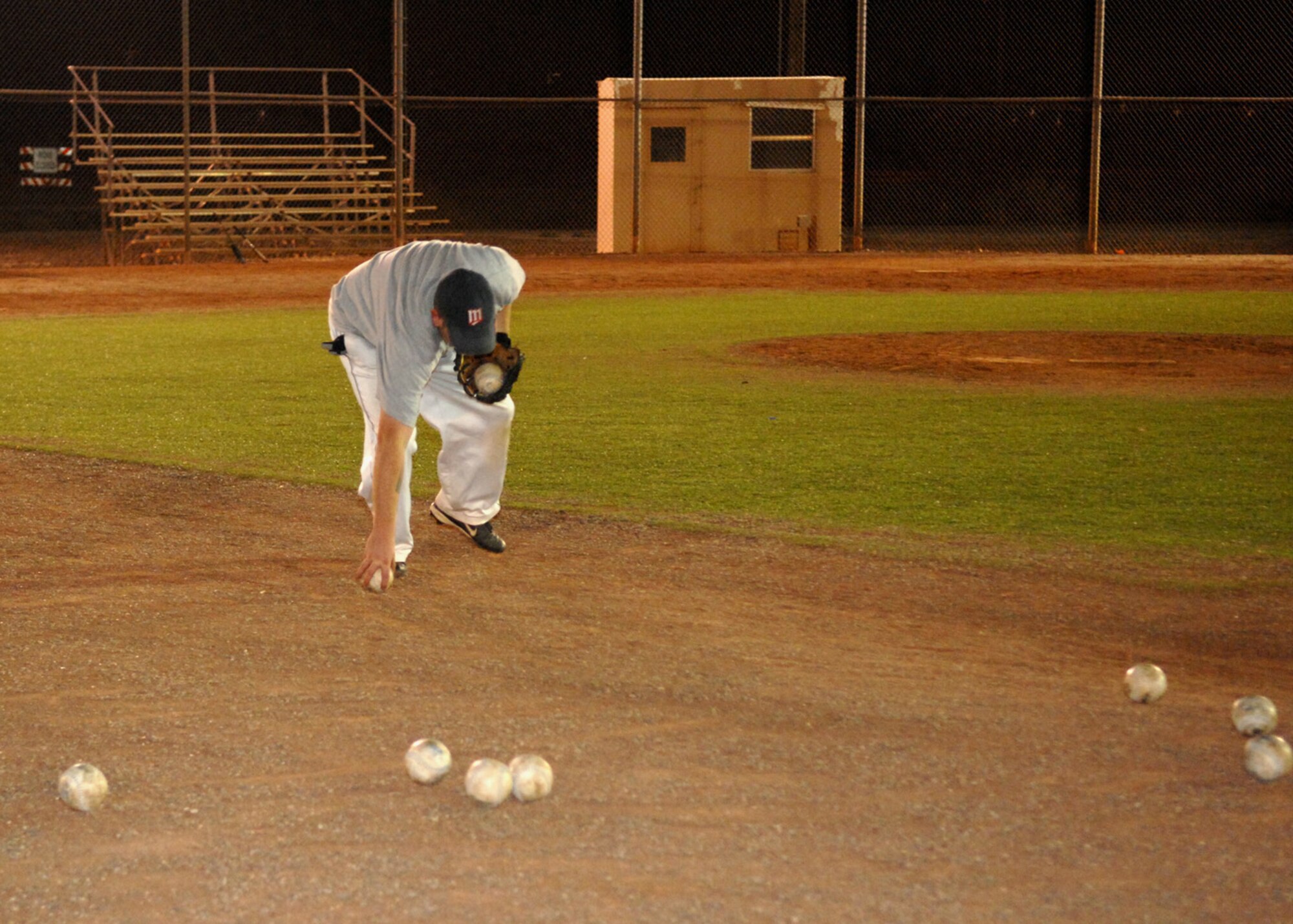 Tech. Sgt. Brent Fangmann, 372 Training Squadron, picks up all the softballs that were used for the varsity softball try-outs at the baseball field at Holloman Air Force Base, N.M., Nov. 13. Members of Holloman practiced all week for a chance to be a part of the base varsity softball team. (U.S. Air Force photo/Airman 1st Class Veronica Salgado)
