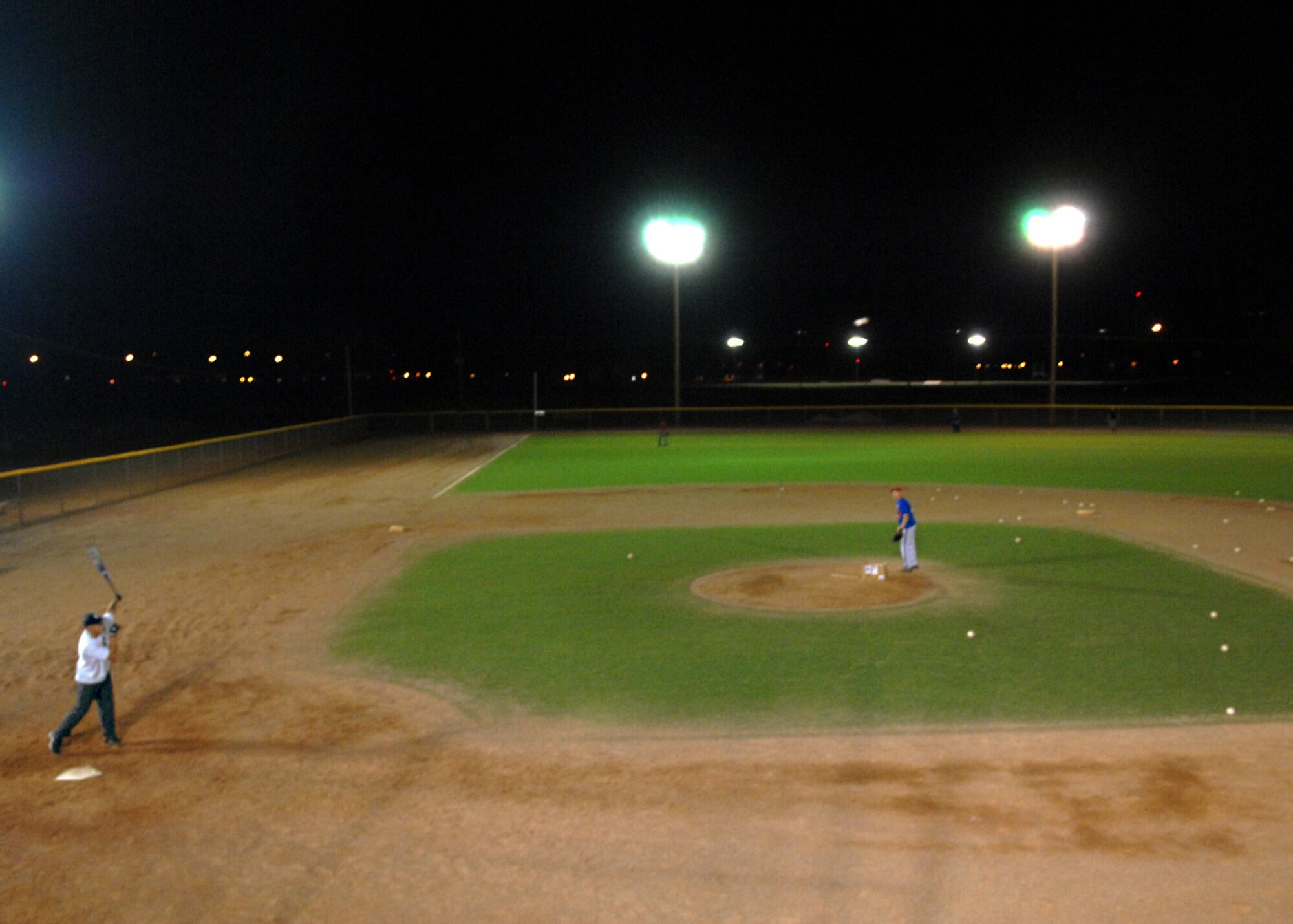 Tech. Sgt. William Velez, 49th Security Force Squadron, swings the bat as Tech. Sgt. Gary Alexander, 49th Logistics Readiness Squadron, pitches the ball during the varsity softball try-outs at Holloman Air Force Base, N.M., Nov. 13. Members of Holloman practiced all week for a chance to be a part of the base varsity softball team. (U.S. Air Force photo/Airman 1st Class Veronica Salgado)
