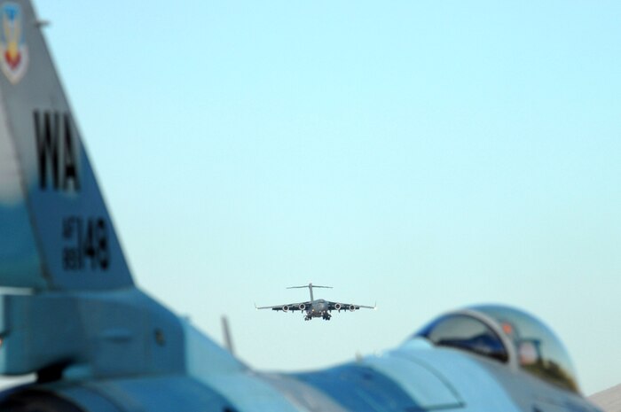 A C-17 Globemaster lands, with an Aggressor F-16 Fighting Falcon in view, during the Mobility Air Forces Exercise, MAFEX, Nov. 19, 2008, Nellis Air Force Base, Nev. Approximately twelve U.S. Air Force bases participate in MAFEX at the U.S. Air Force Weapons School twice a year, testing C-17 Globemasters and C-130 Hercules crews' ability to join together in formation at a specific time and location to drop a brigade-size force anywhere in the world. (USAF photo/Staff Sgt. Kenny Kennemer)