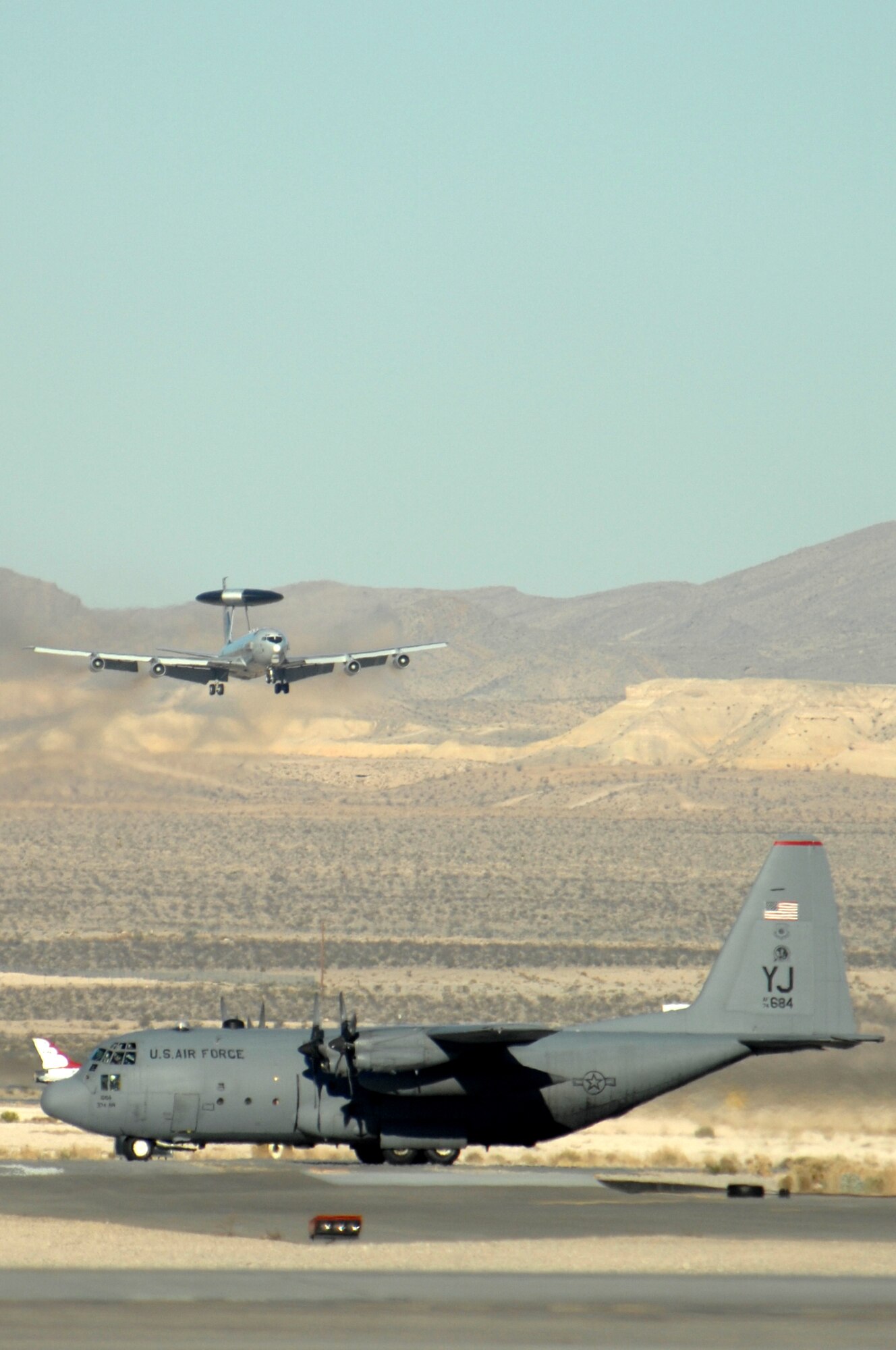 A C-130 Hercules taxis while an E-3 Sentry Airborne Warning and Control System lands during the Mobility Air Forces Exercise, MAFEX, Nov. 19, 2008, Nellis Air Force Base, Nev. Approximately twelve U.S. Air Force bases participate in MAFEX at the U.S. Air Force Weapons School twice a year, testing C-17 Globemasters and C-130 Hercules crews' ability to join together in formation at a specific time and location to drop a brigade-size force anywhere in the world. (USAF photo/Staff Sgt. Kenny Kennemer)
