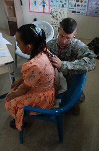 Capt. (Dr.) David Armstrong, a flight surgeon with the 1-228th Aviation Regiment, listens to the lungs of a patient during a disaster relief medical mission Nov. 14 in Crooked Tree, Belize. More than 600 people were seen in two villages during the three-day mission.