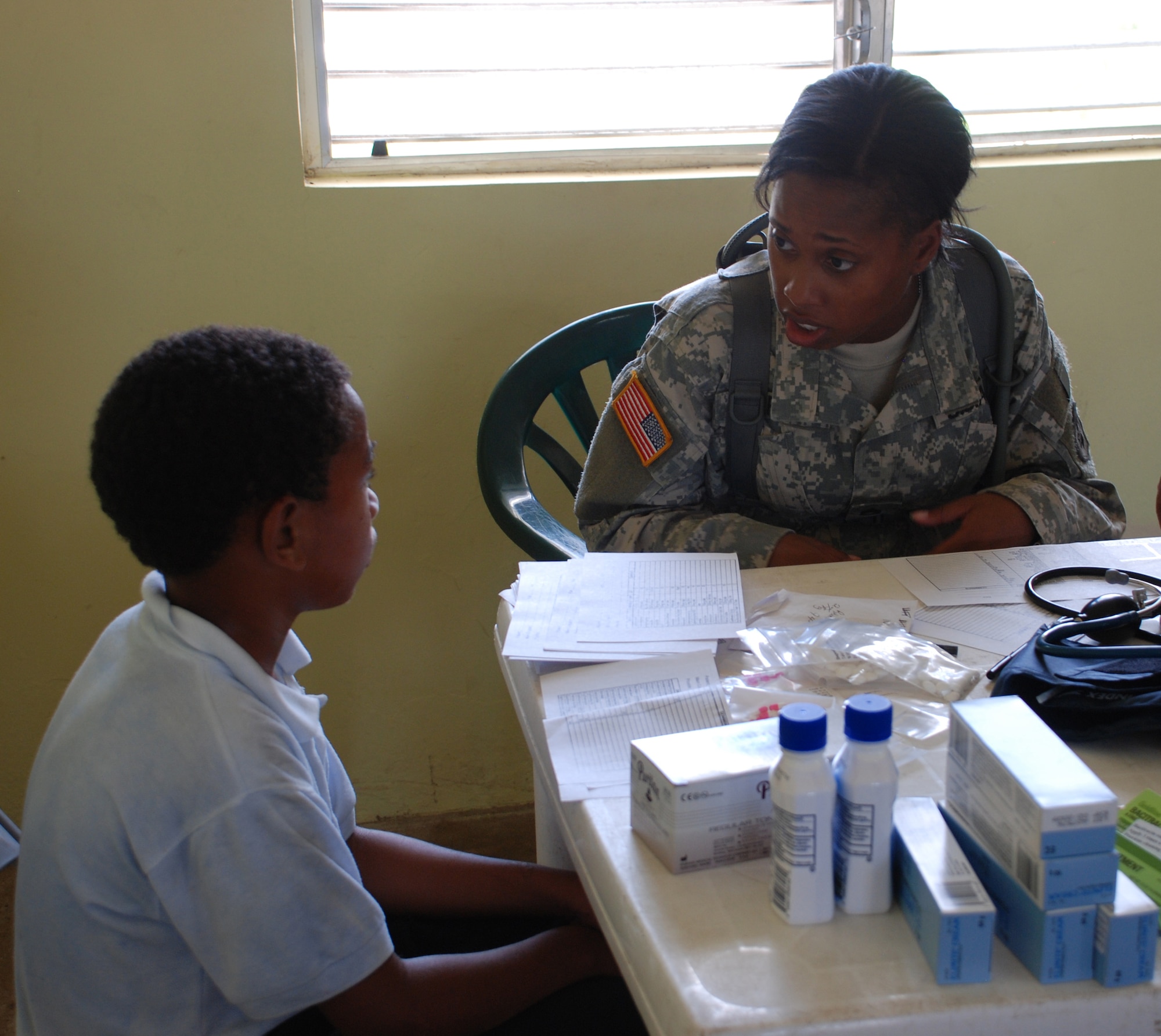 Army Staff Sgt. Jenise Harris speaks to a young patient in Burrell Boom, Belize. More than 600 people were seen during a three-day disaster relief medical assistance visit by JTF-Bravo to the Belize villages of Burrell Boom and Crooked Tree.