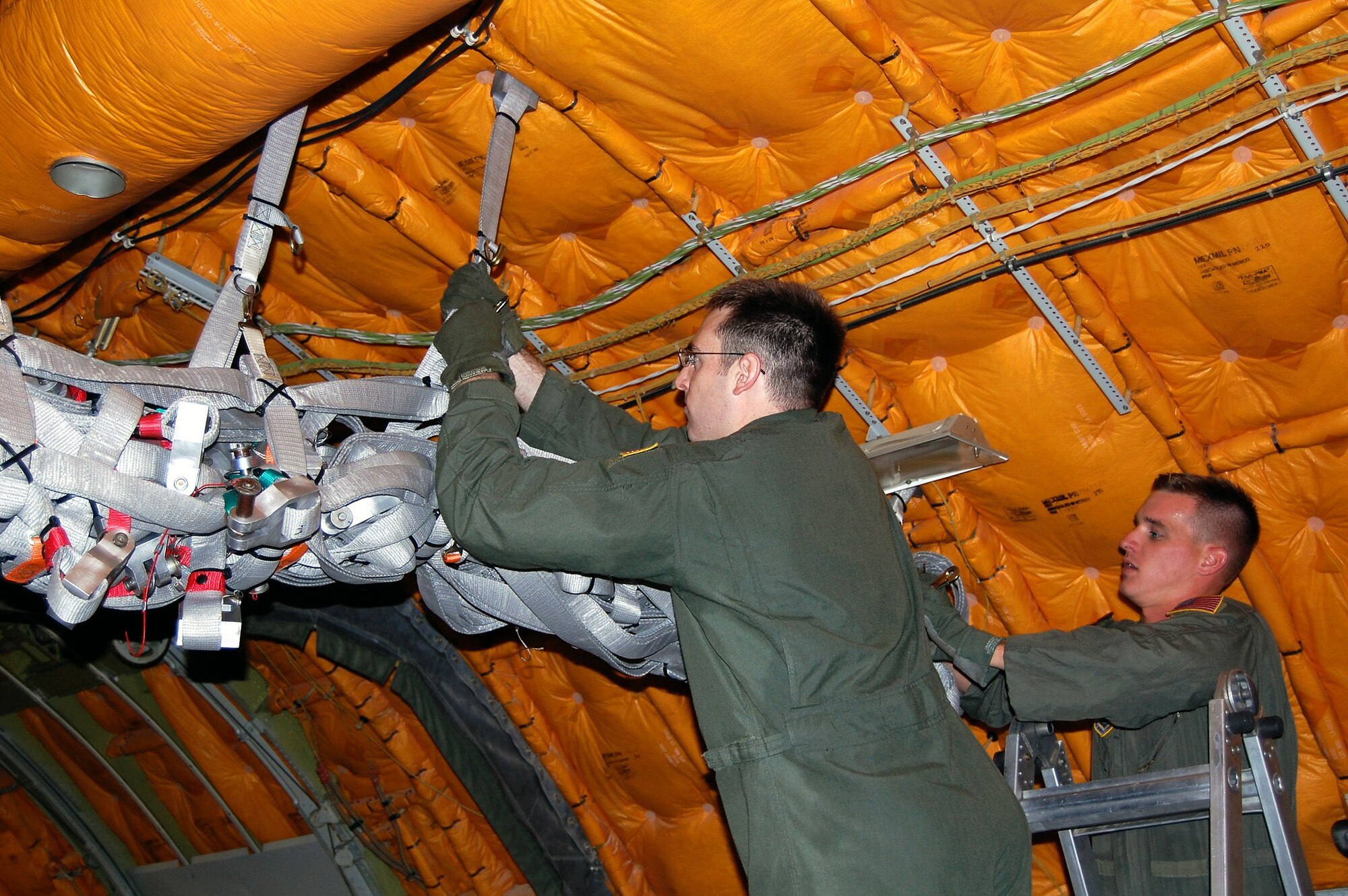 Boom operators from McGuire Air Force Base, N.J., install an alternative, lightweight cargo net inside a KC-10 Extender Sept. 16 as part of a demonstration for the Air Mobility Battlelab. The demonstration was for the battlelab's KC-10 Lightweight Cargo Net and Hoist Initiative which was recommended for use to Air Mobility Command.  It was one of the last initiatives of the AMB, which deactivated Sept. 24 at the U.S. Air Force Expeditionary Center on Fort Dix, N.J. (U.S. Air Force Photo/Tech. Sgt. Scott T. Sturkol)