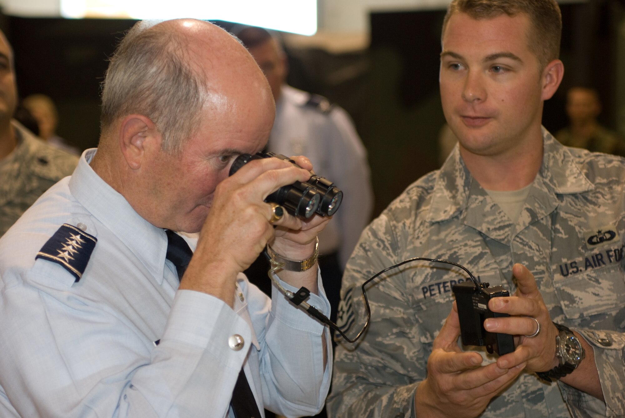 Gen. Duncan McNabb, U.S. Transportation Command commander, views equipment with a pair of night vision goggles, as Tech. Sgt. Ryan Peterson, 570th Global Mobility Readiness Squadron, looks on Nov. 13.  General McNabb received an in-depth look at the 615th CRW through one-on-one briefings, as well as a tour of the wing?s newest facility during his visit to Travis Air Force Base.   (U.S. Air Force photo/Wendy Zippwald)