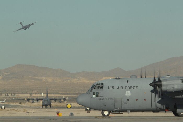 C-130 Hercules taxi while a C-17 Globemaster lands during the Mobility Air Forces Exercise, MAFEX, Nov. 19, 2008, Nellis Air Force Base, Nev. Approximately twelve U.S. Air Force bases participate in MAFEX at the U.S. Air Force Weapons School twice a year, testing C-17 Globemasters and C-130 Hercules crews' ability to join together in formation at a specific time and location to drop a brigade-size force anywhere in the world. (U.S. Air Force photo/Senior Airman Brian Ybarbo)
