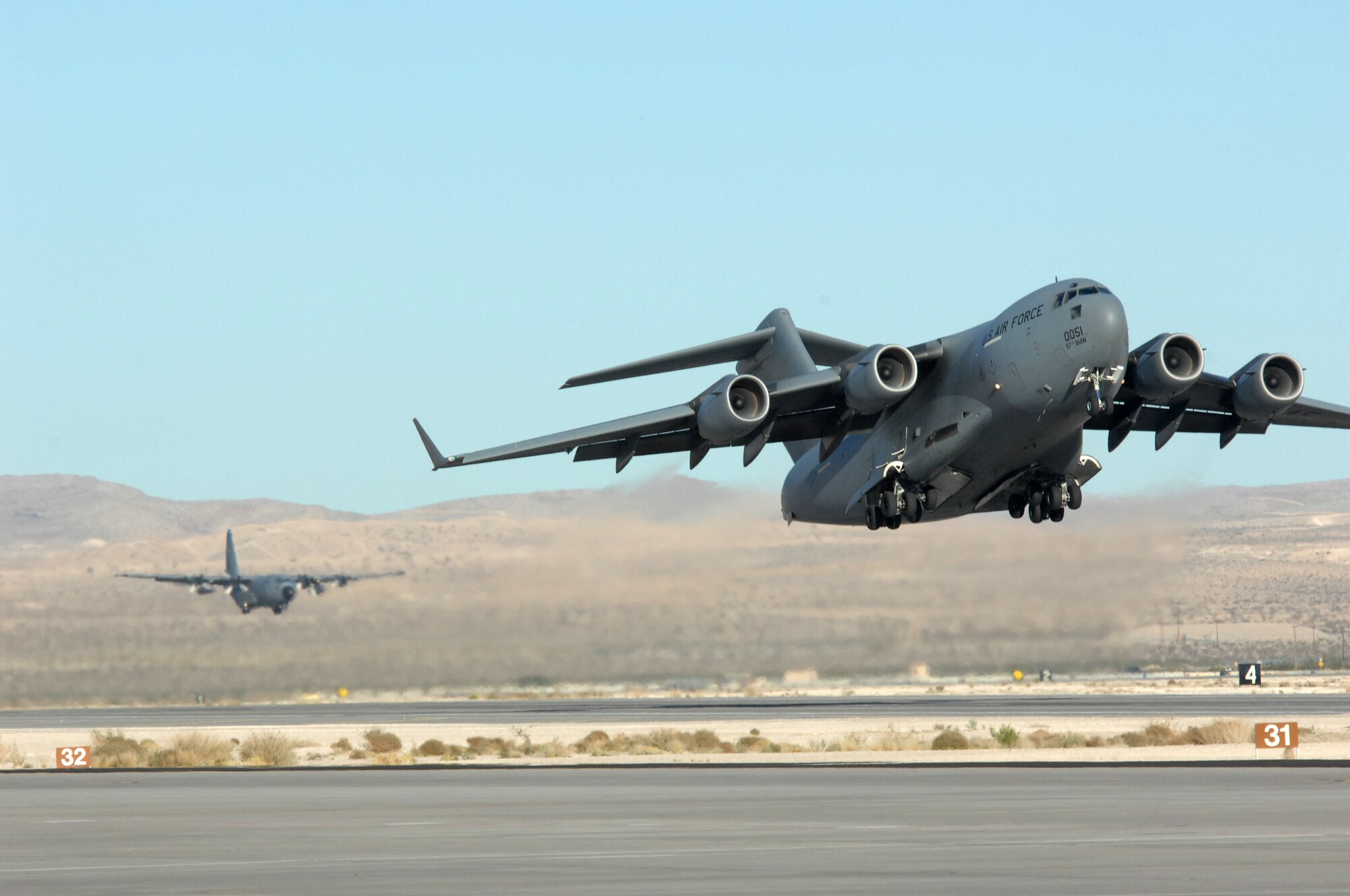 A C-17 Globemaster and C-130 Hercules fly in the Mobility Air Forces Exercise, MAFEX, Nov. 19, 2008, Nellis Air Force Base, Nev. Approximately twelve U.S. Air Force bases participate in MAFEX at the U.S. Air Force Weapons School twice a year, testing C-17 Globemasters and C-130 Hercules crews' ability to join together in formation at a specific time and location to drop a brigade-size force anywhere in the world.
